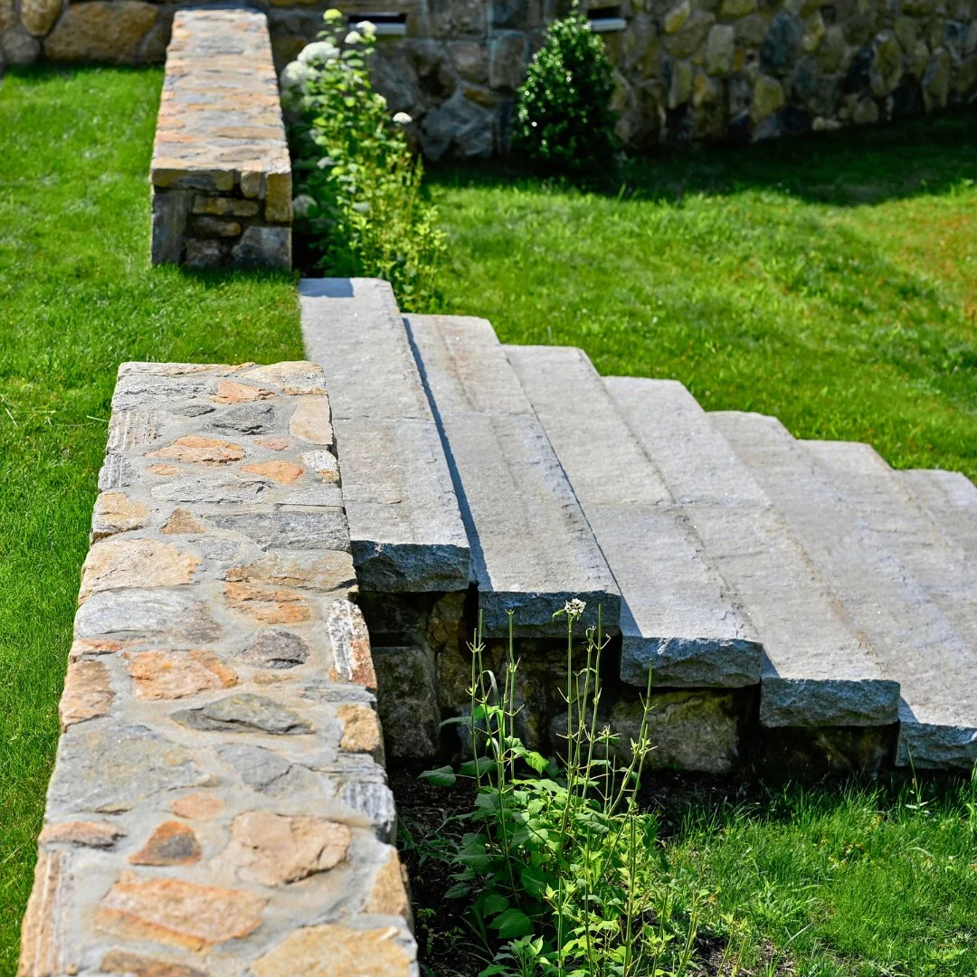 This fieldstone wall with limestone steps leading to the pool is both functional and timeless.