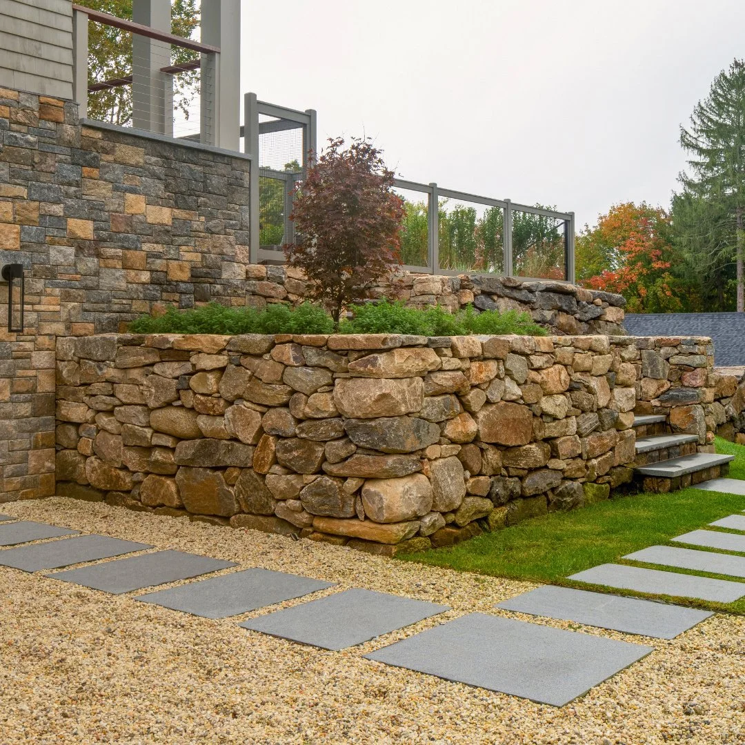 A backyard that brings it all together. This home features a beautiful mix of fieldstone and Liberty Hill veneer, paired with NJ pea stone gravel and Newport Dark steps for a clean, timeless outdoor look.