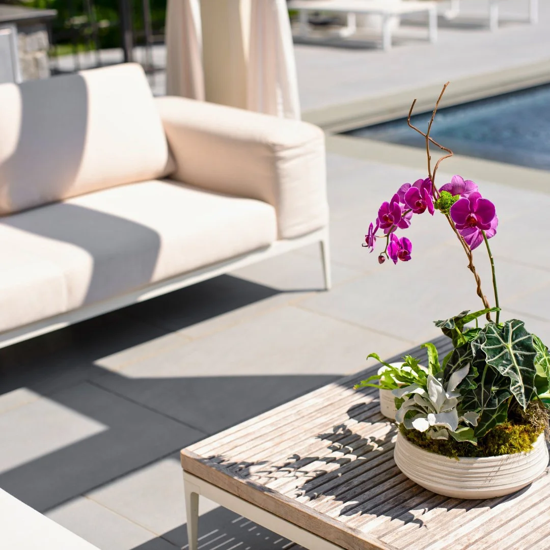 A simple touch of stone makes all the difference. This patio featuring The Gault Collection's Riverside Blue creates the perfect setting for outdoor dining, fresh flowers, and relaxed seating.