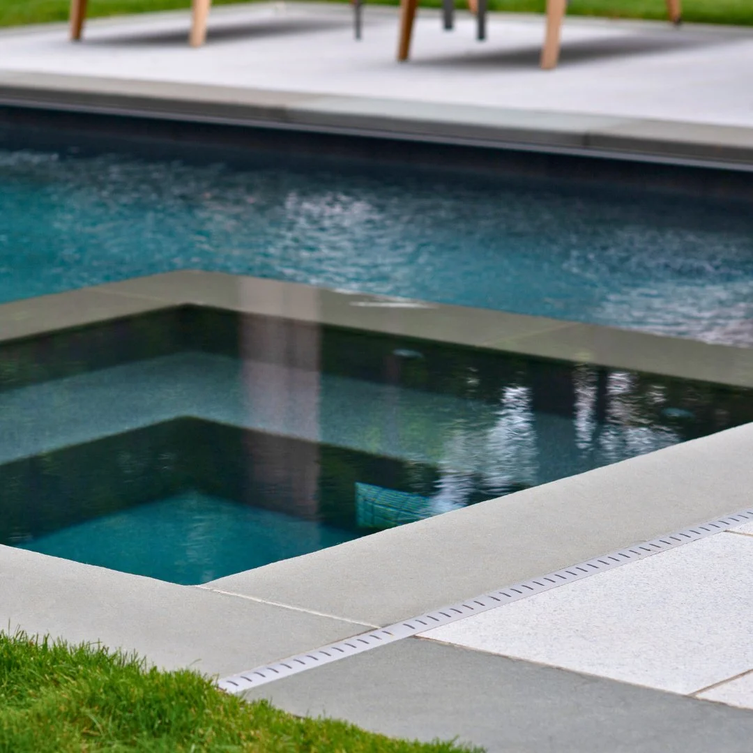 Sleek, modern, and timeless. Thermal Bluestone coping gives this Marsh Grey Porcelain patio a striking look.