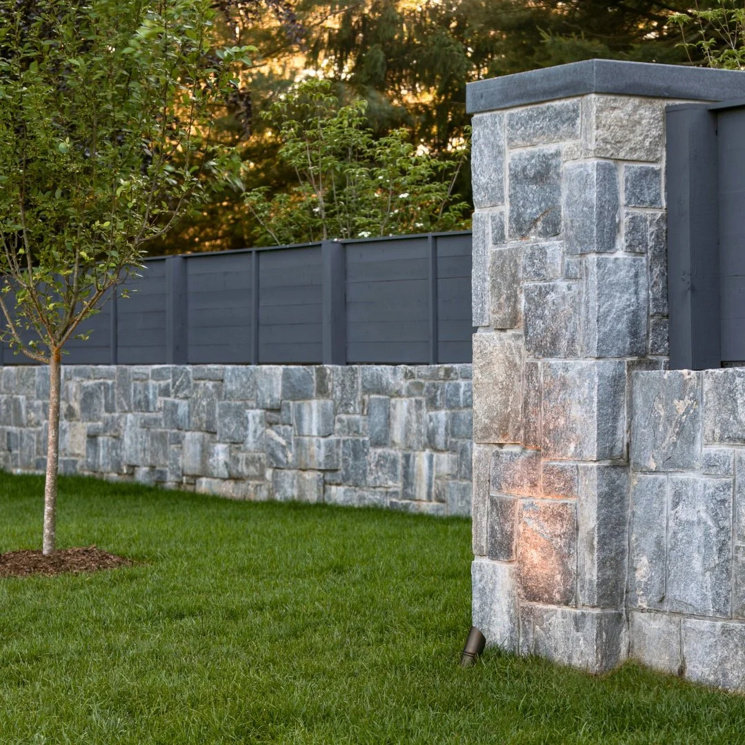 This Liberty Hill wall, finished with Newport Dark caps and topped with fencing, adds structure, privacy, and timeless character to the backyard. A functional feature that enhances the landscape while standing strong for years to come.