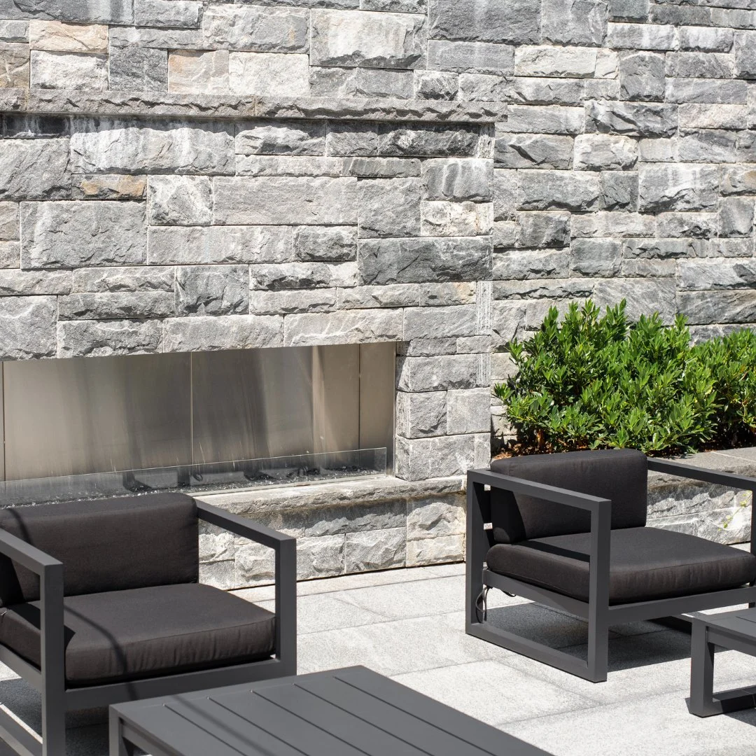 Whether you're looking to add to your home or refresh a commercial space, a fire feature is always the right call! This full wall version features a sawn bed of Salem dark granite veneer.