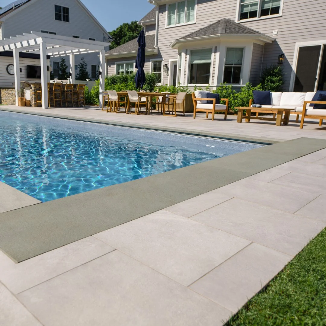 Summer living at its best! A beautifully designed Porcelain patio with Bluestone pool coping with an outdoor kitchen and comfortable seating creates the perfect space for entertaining, relaxing, and enjoying long June days with family and friends.