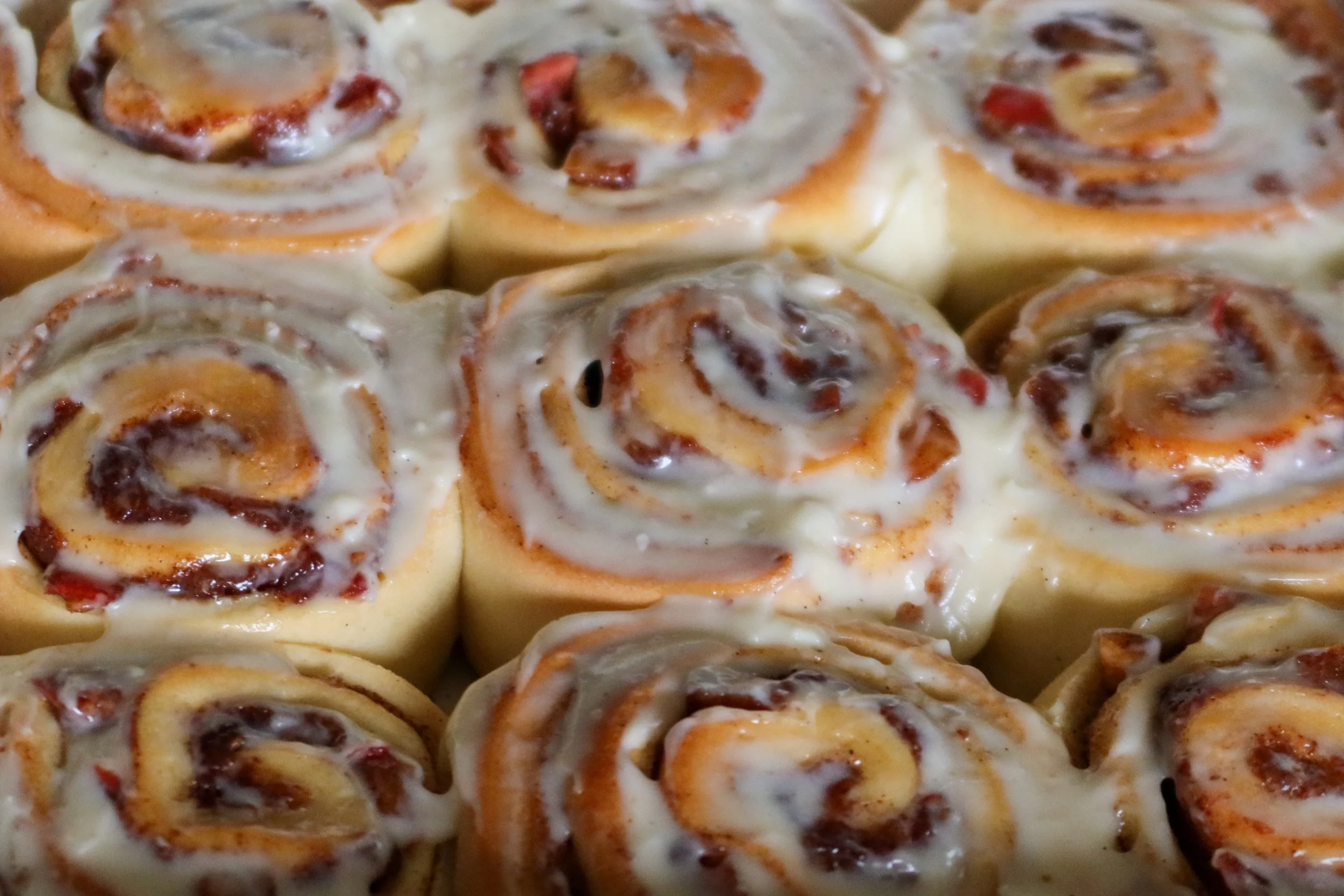 Cozy apple-filled cinnamon rolls with warm icing, baked in a cottage-style dish.