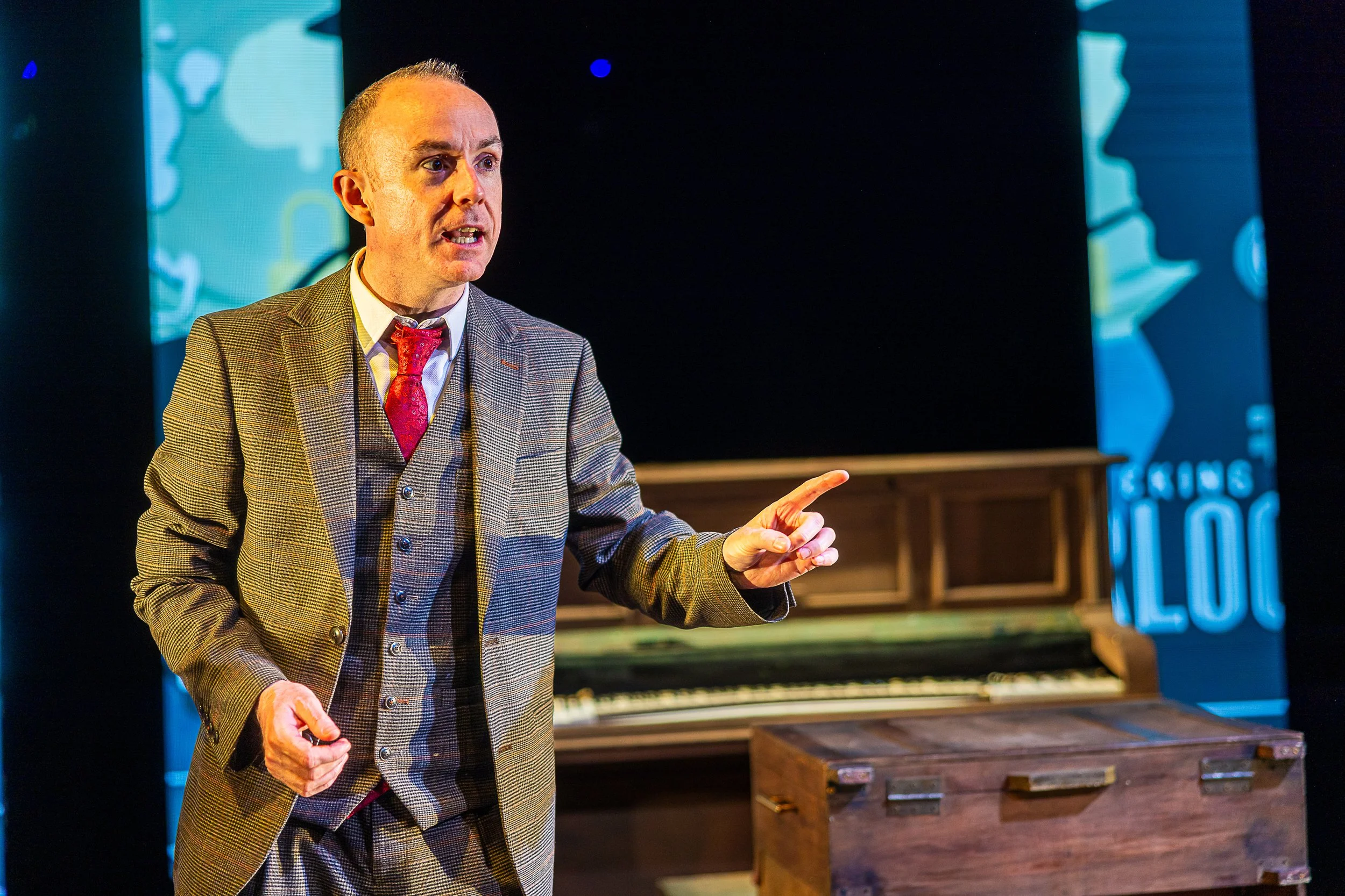 Magician Caolan McBride points enthusiastically as he performs his magic live on stage.