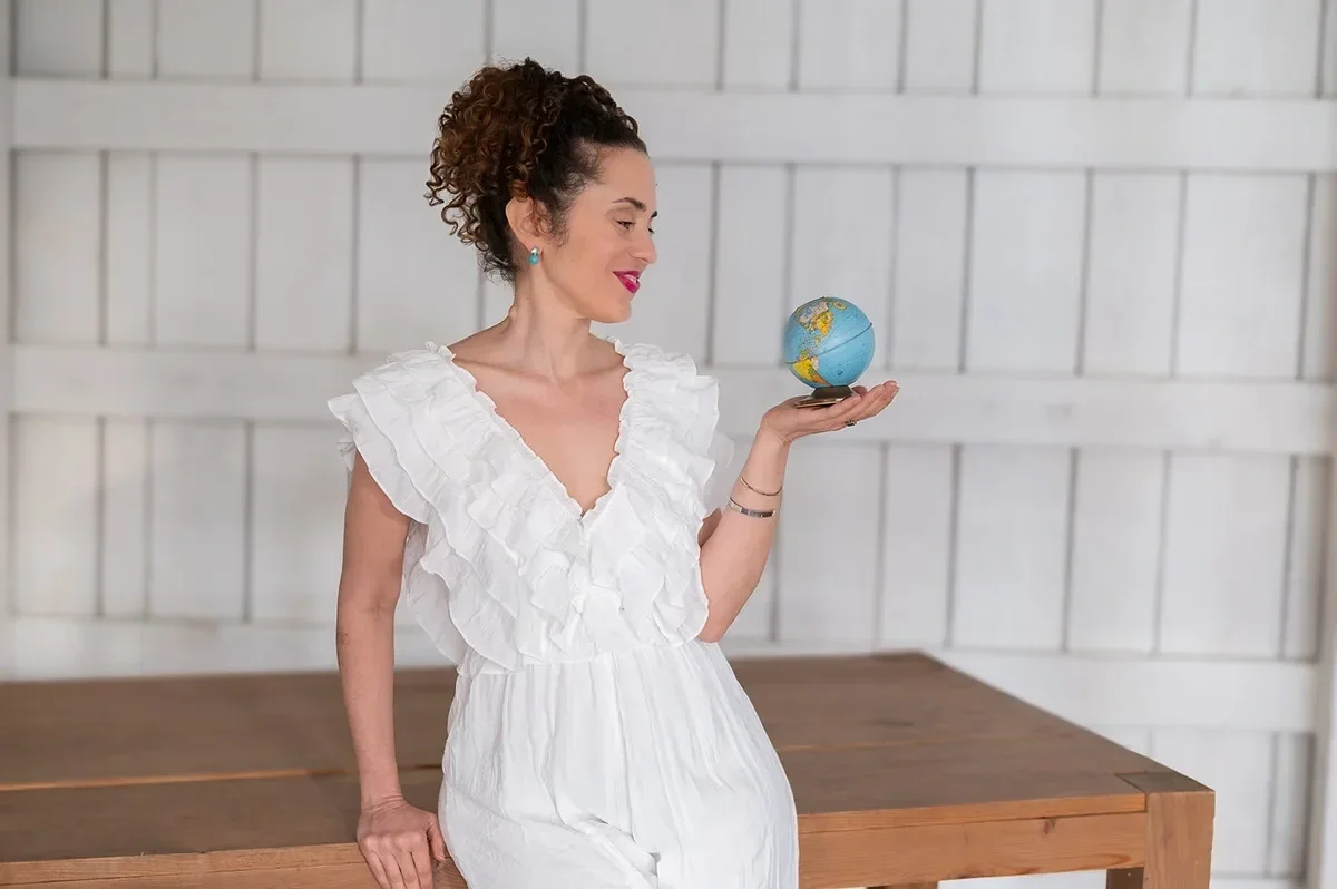 Katrina McGhee holding a small globe, gazing at it as a career break and sabbatical planning coach