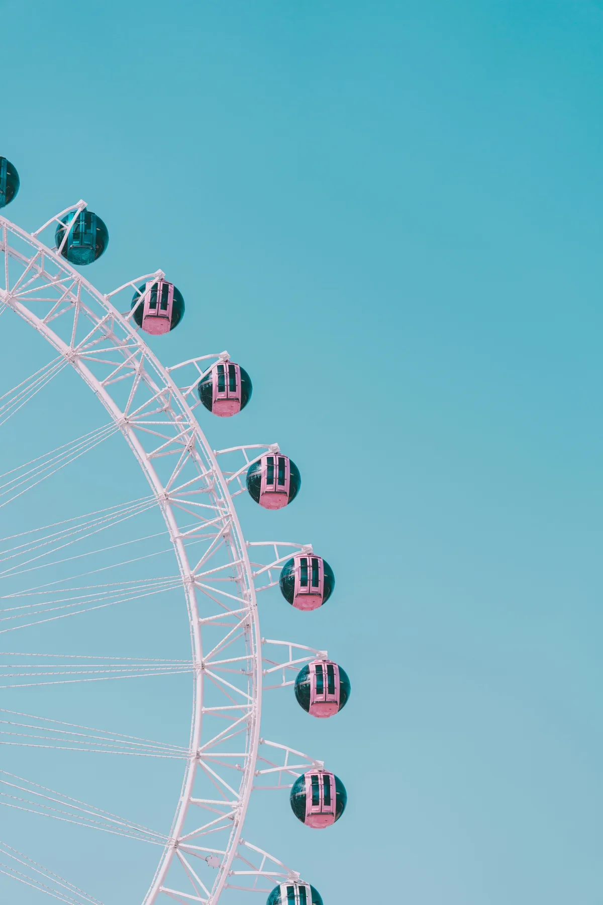ferris-wheel-pink-cabins-teal-sky-1200w.webp
