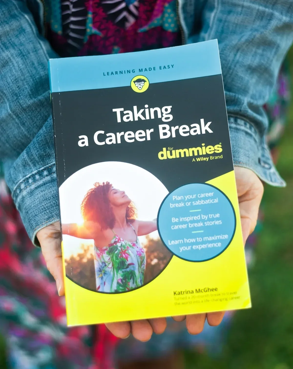 Hands holding Taking a Career Break for Dummies book by Katrina McGhee outdoors