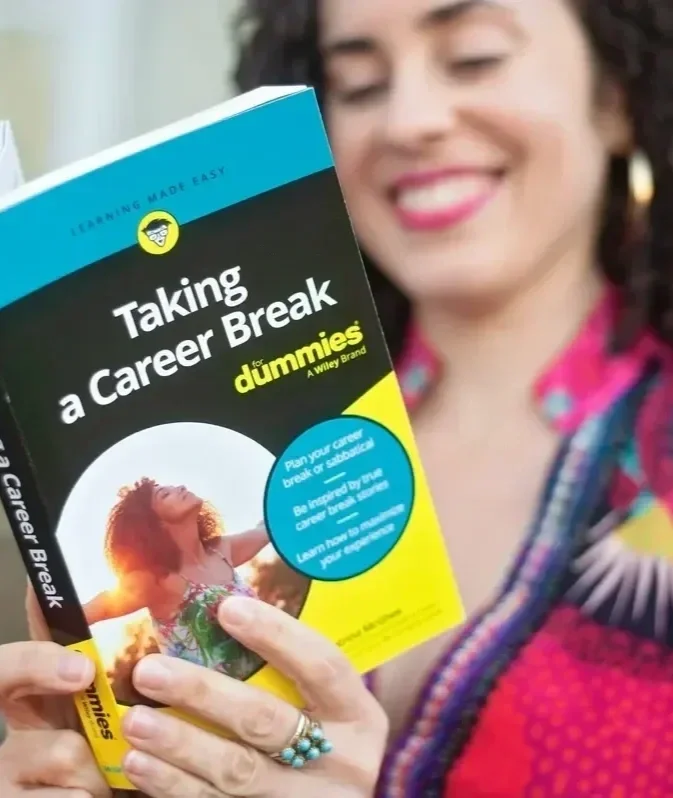 Smiling career break coach holding Taking a Career Break For Dummies book outdoors