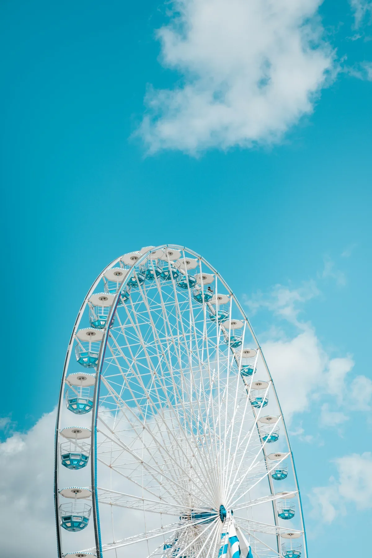 White Ferris wheel against a bright blue sky, evoking leisure and career break joy