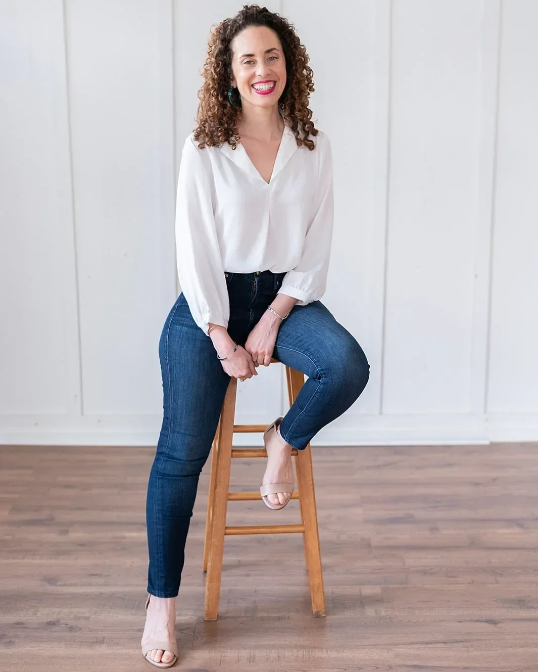 Katrina McGhee career break coach seated on wooden stool smiling in white blouse and jeans