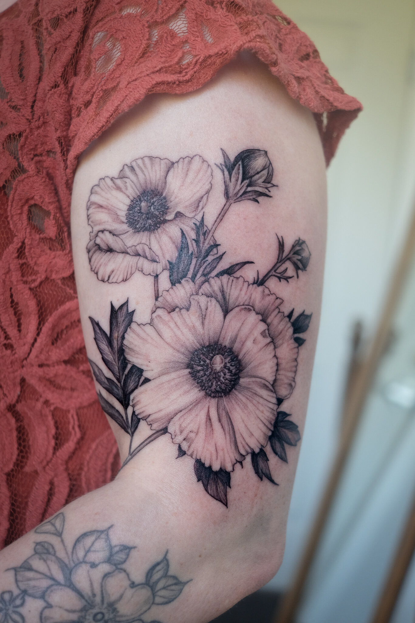 Inner arm tattoo of a poppy