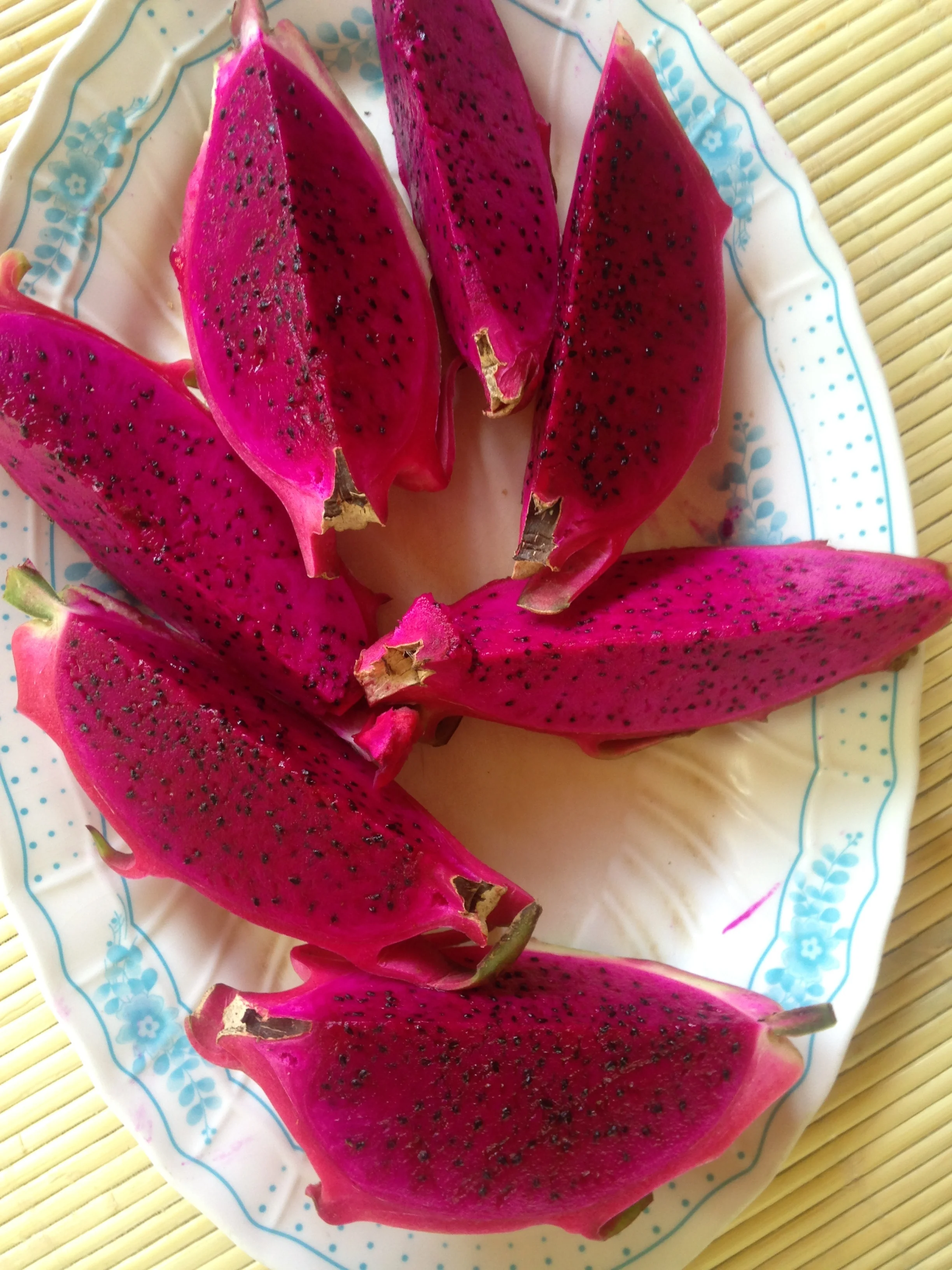 Slices of red dragon fruit on a decorative plate