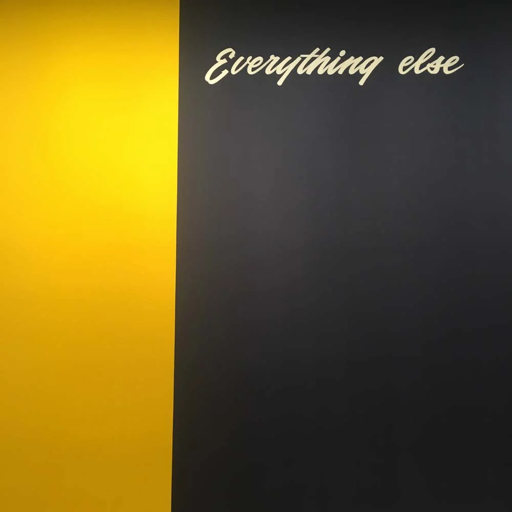 Wall with yellow and black panels, the black panel has the words 'Everything else' written on it.