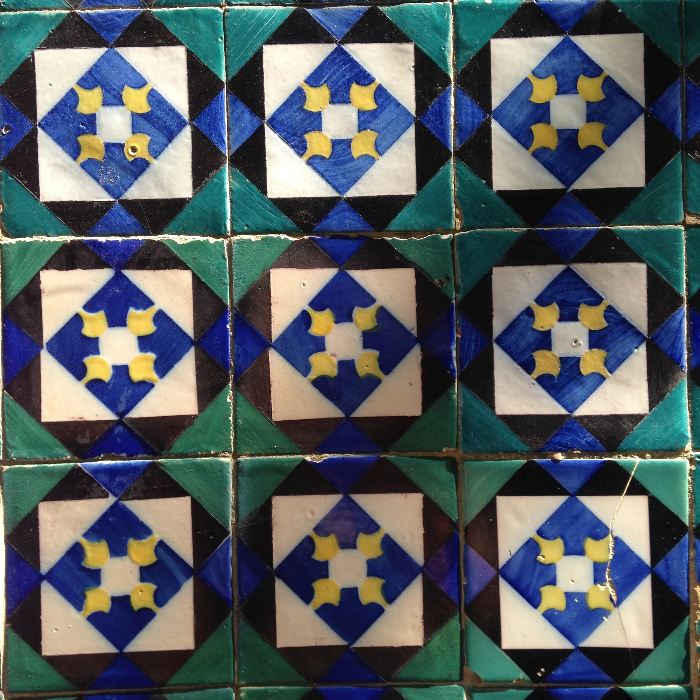 Decorative ceramic tiles with geometric patterns in blue, green, yellow, and white.