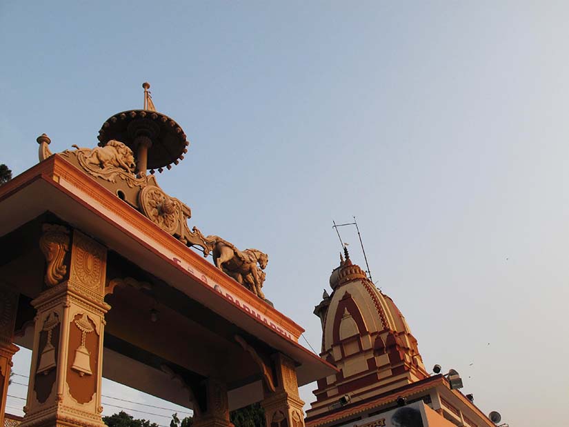Hindu temple with ornate architecture and sculptures under a clear sky.