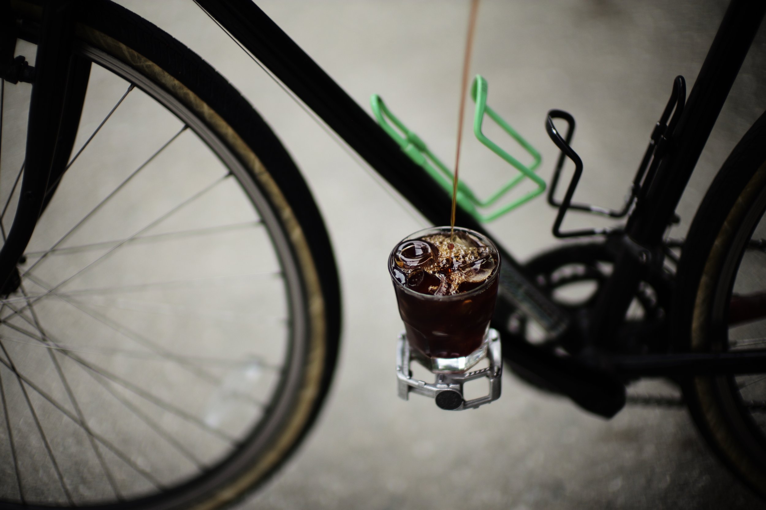 pouring cold brew in glass cup on bike pedal