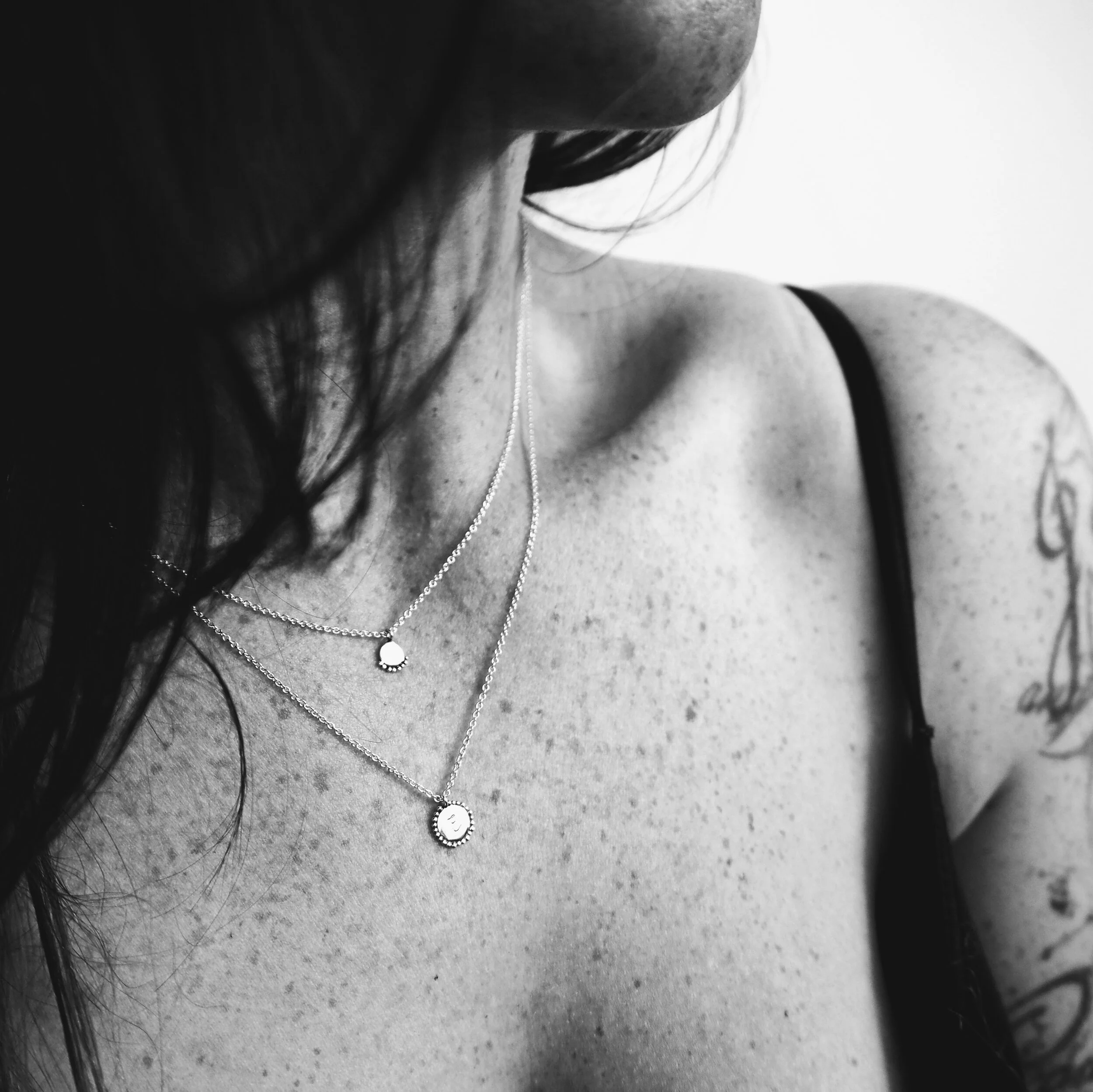 Sol Sun necklace worn layered 