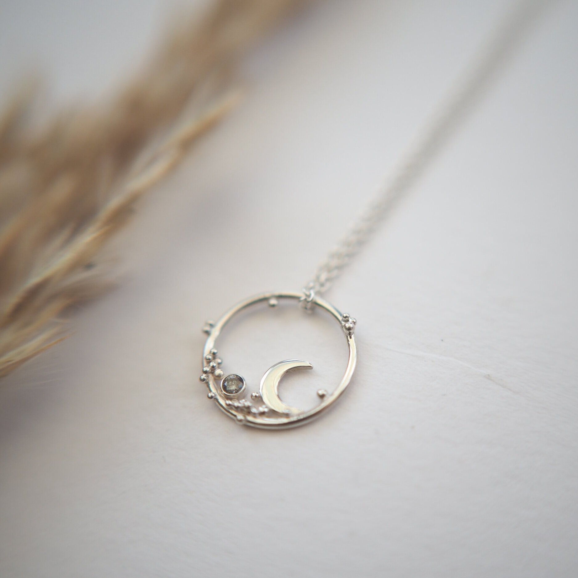 Recycled silver crescent moon pendant with silver starts scattered across and a salt and pepper diamond