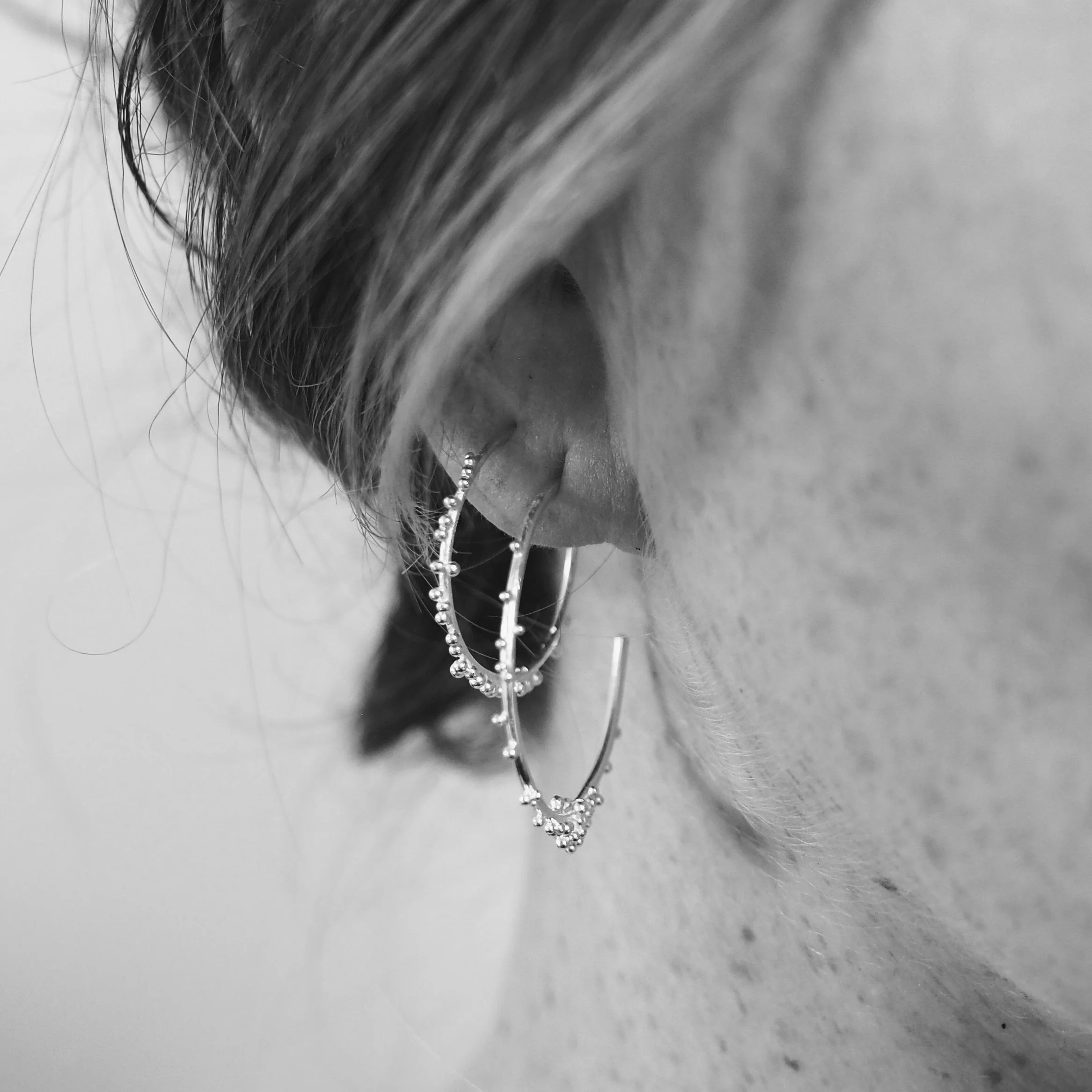 Recycled silver sol hoop earrings worn with large hoop earrings