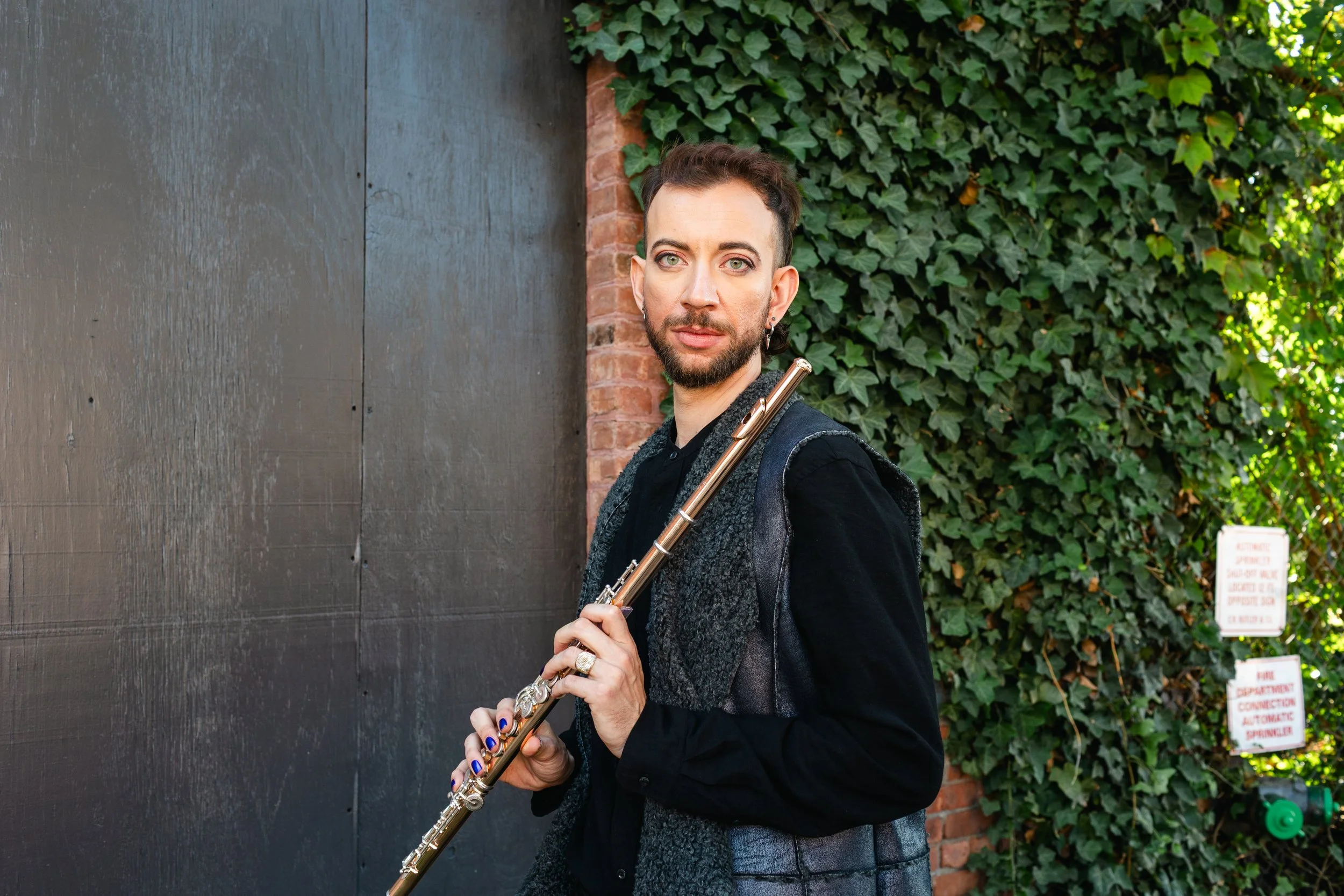 Yoshi Weinberg Headshot with Flute and Leafy Background