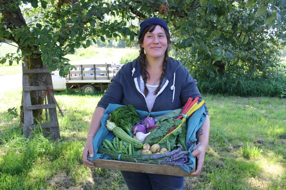 Camp Out collaborator Marianne Copene displays a CSA from Wobbly Cart Farm. Wobbly Cart donated lots of fresh vegetables for campers to eat and lead a tour of the farm for campers to learn about where their food was grown.