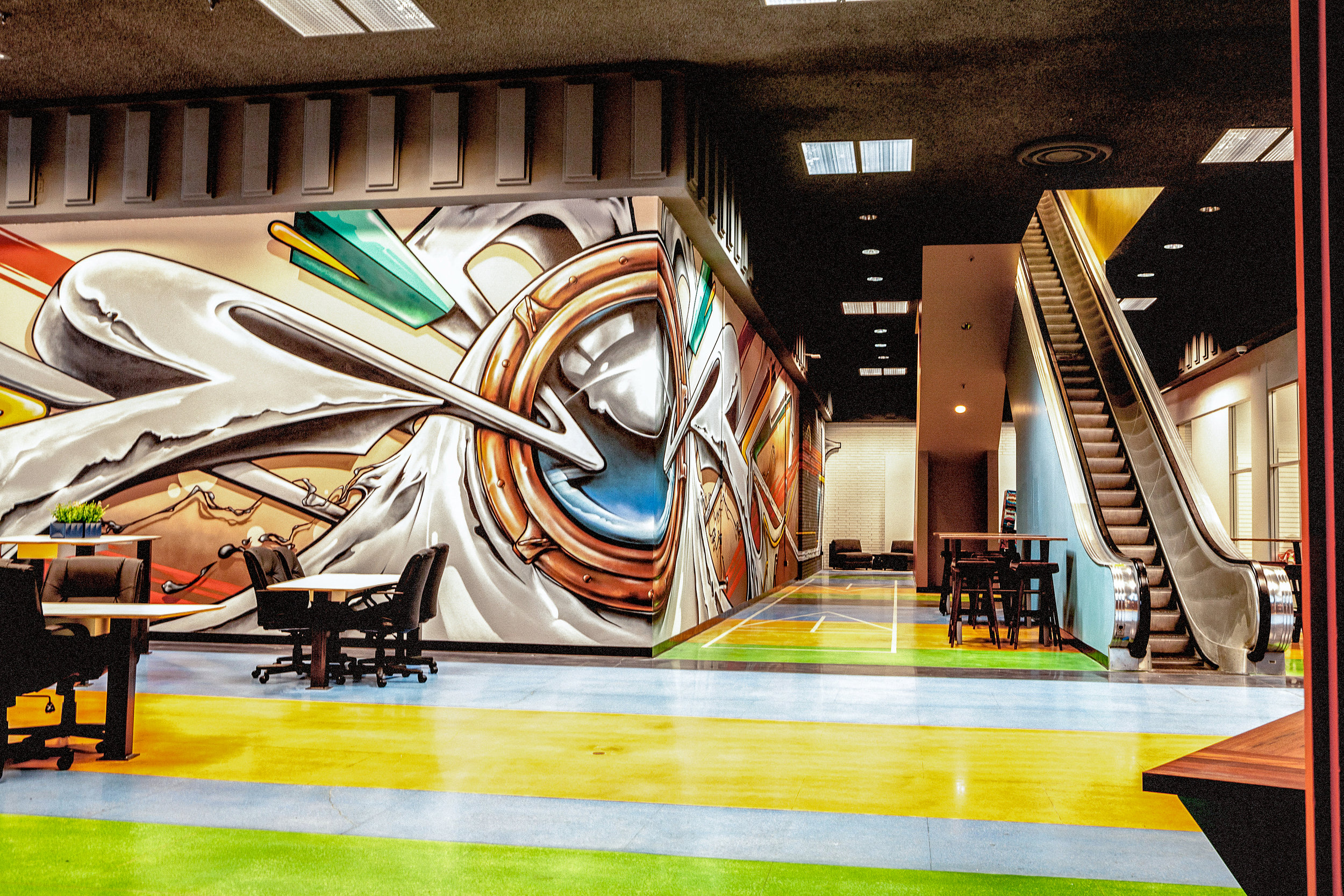  The first floor has hopscotch &amp; shuffle board dyed into the striped, multi-colored floor; a sea of white, articulated seating and tables are found along the 120 ft. long graffiti mural by Sean Griffin (Griffin One). 