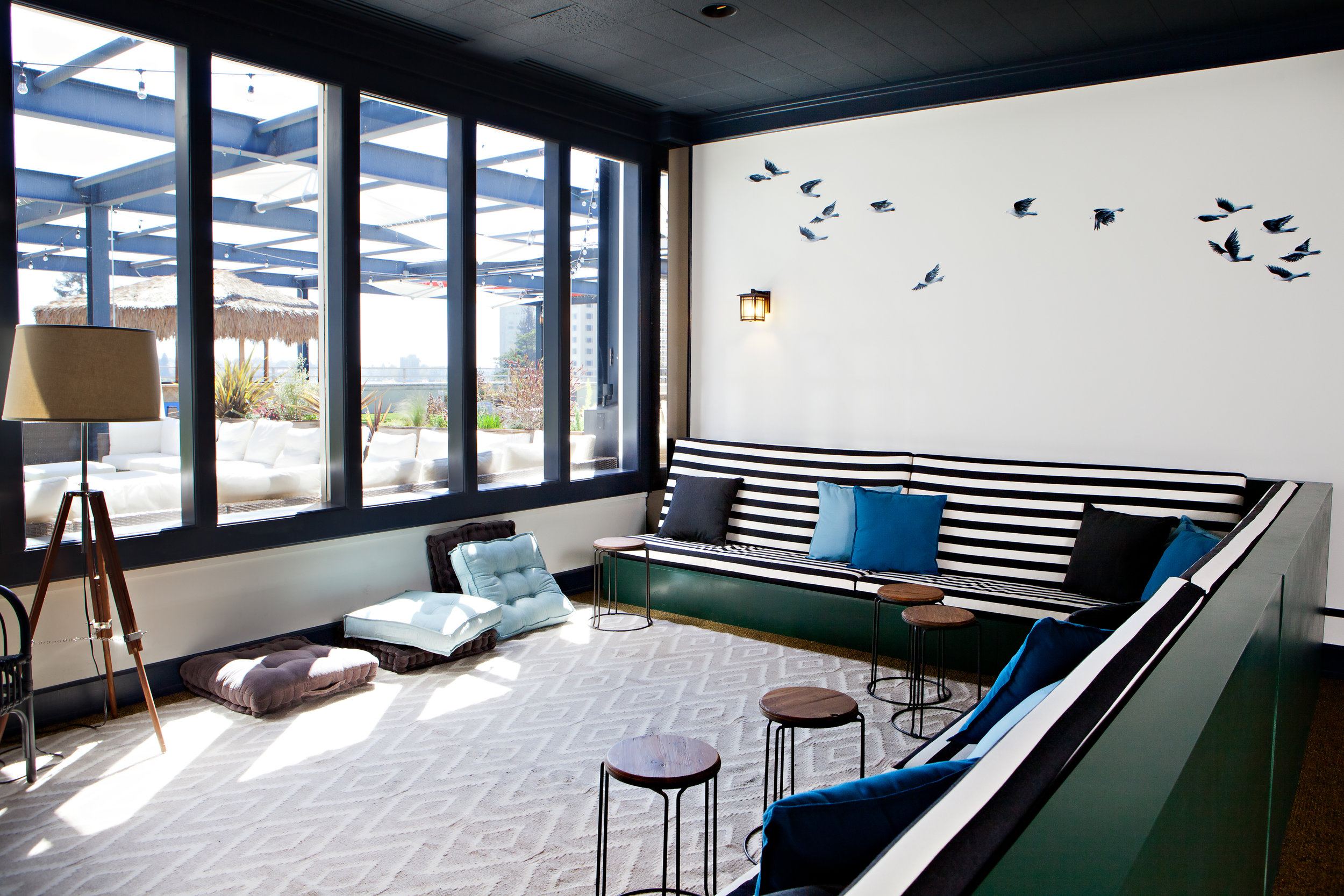The birds wall mural continues into the next seating area, another custom made couch piece by Because We Can.