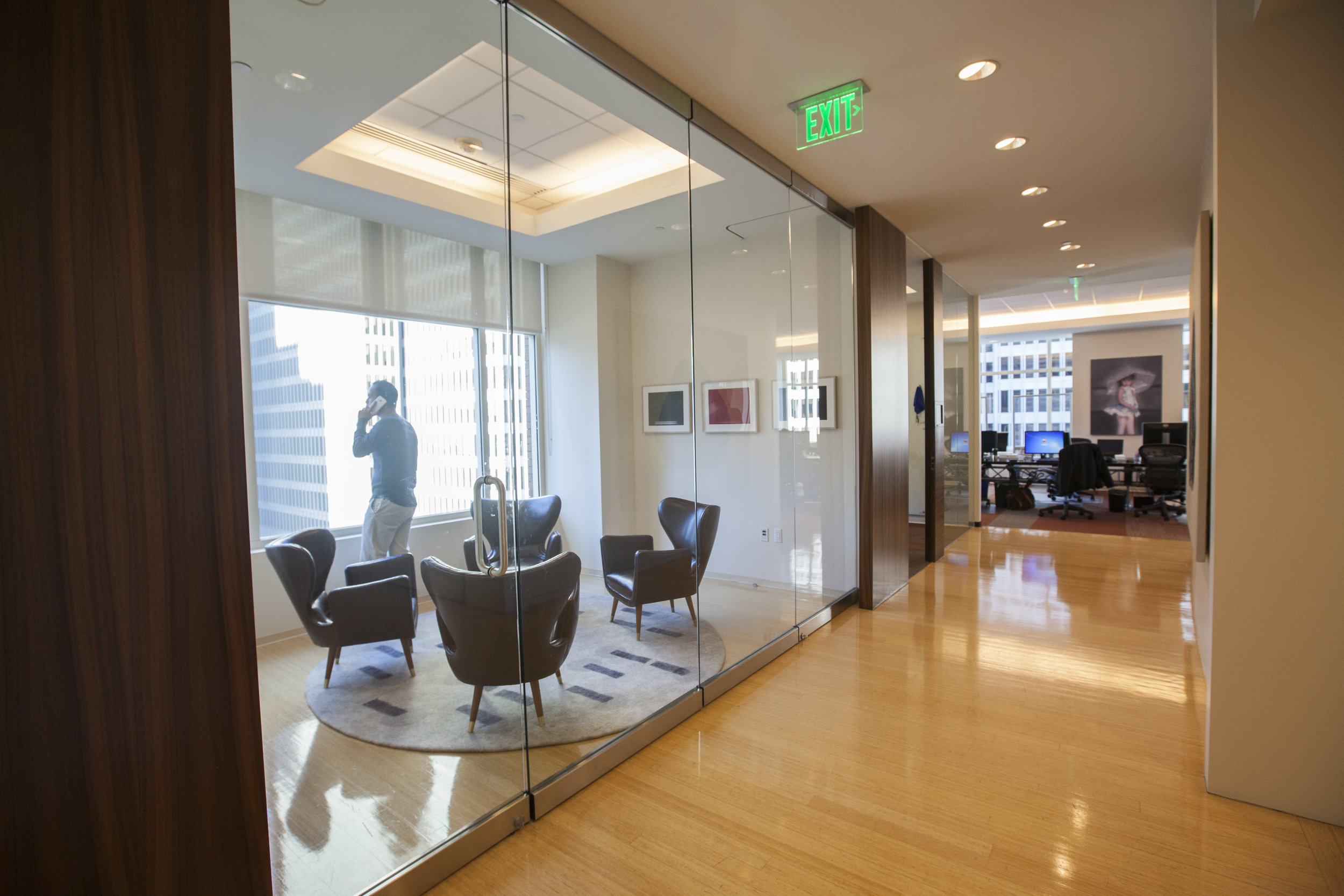  As you round the corner of the elevator lobby, the hall leads you to a private meeting space flanked by offices and conference rooms. Now with this operational glass wall it has the ability to be fully closed off with a door, or a fully open space. 