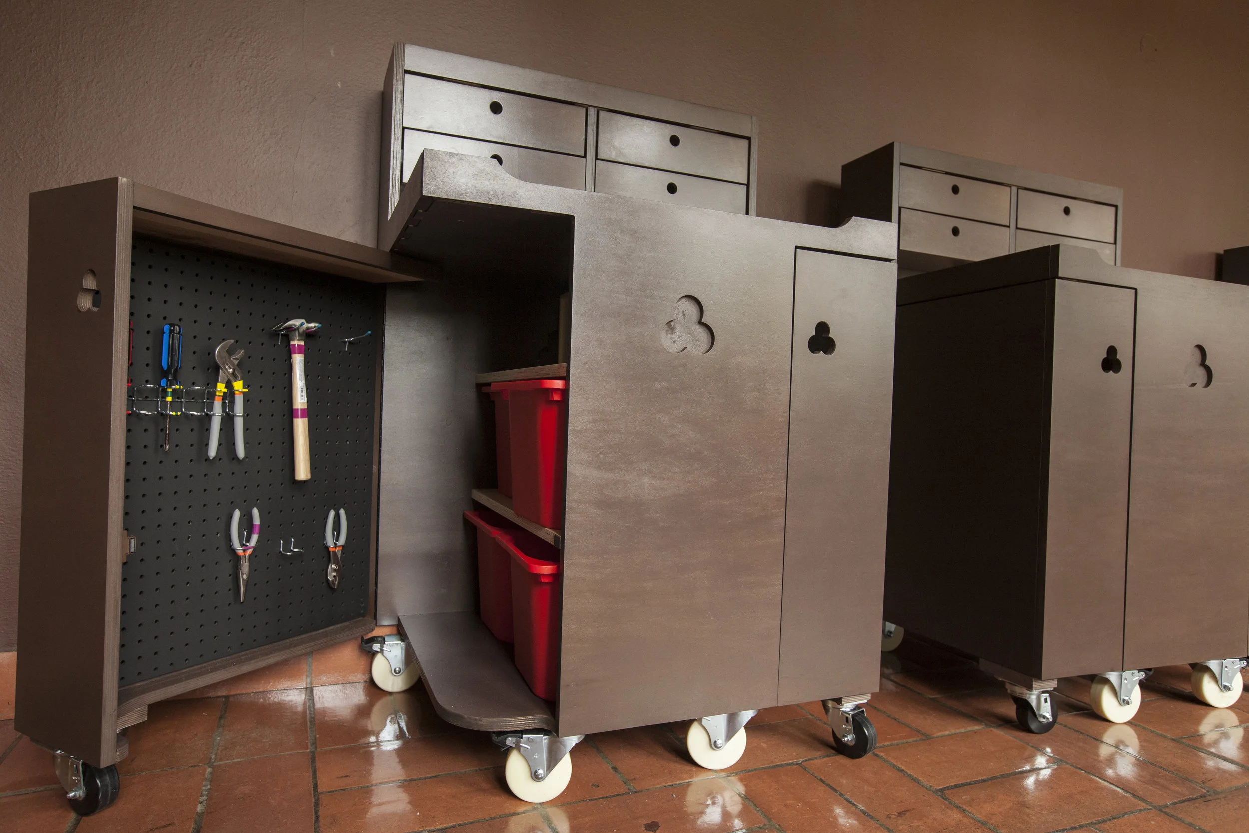 The doors open completely to allow access to the pegboard of tools, the white board for notes, and the central cavity with ample storage for projects and parts.