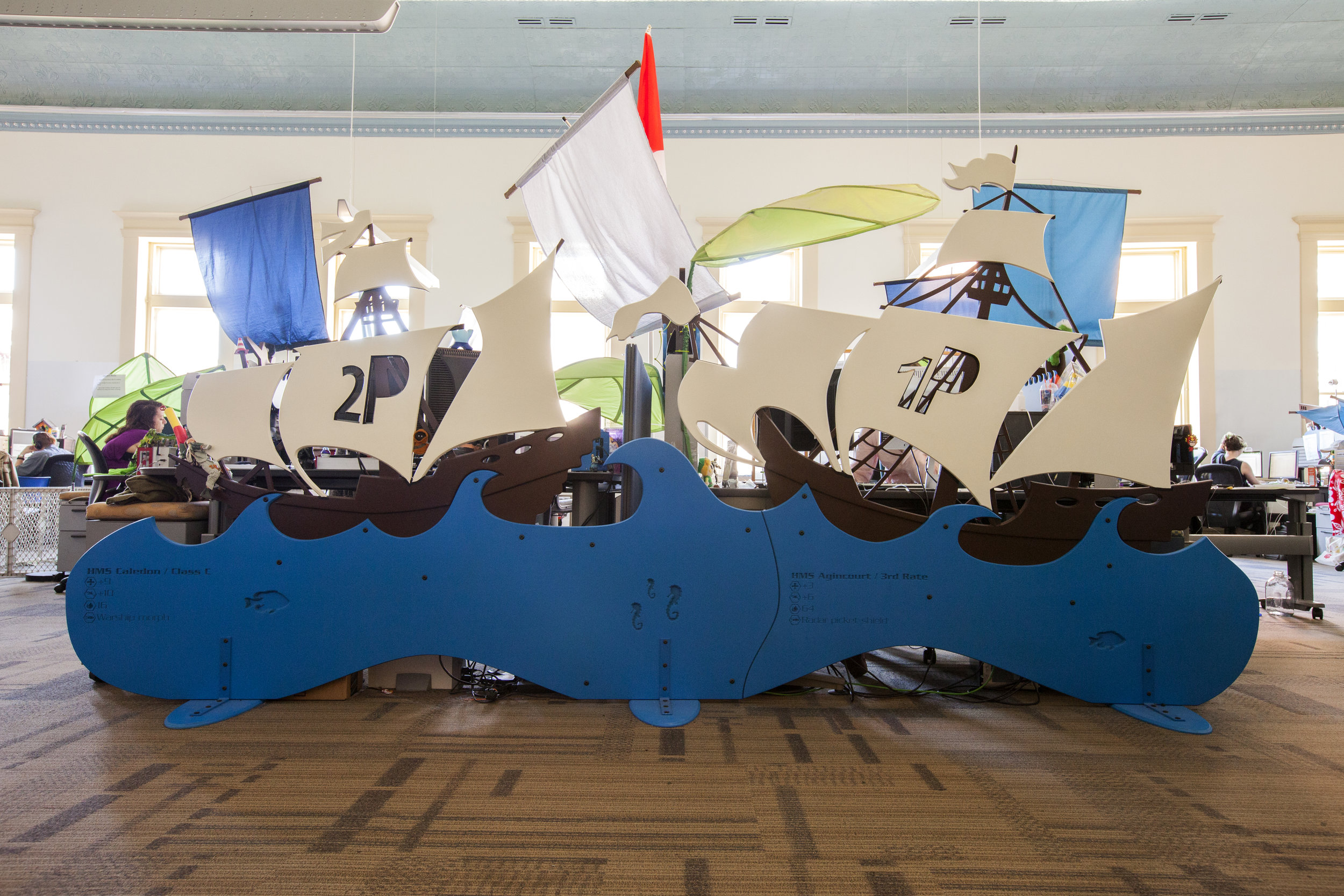 The new 'ship' dividers in the office add a fun aesthetic to this small video game designer space.