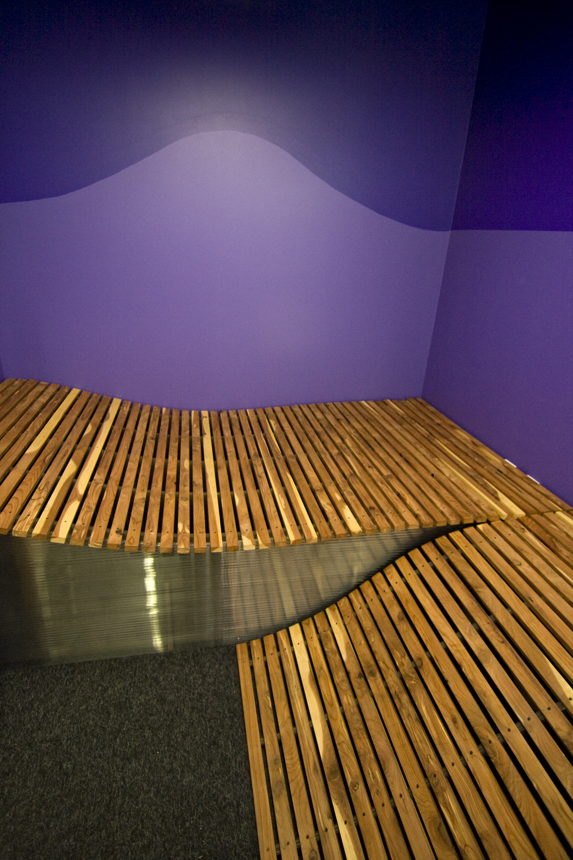 A frame for the cedar planks was made to fit exactly into the small room. The planks then had a 'plug and play', quick and easy construction into the space. The smell of the cedar and the gentle curve of the planks, make this a relaxing 'chill' room for students to decompress.