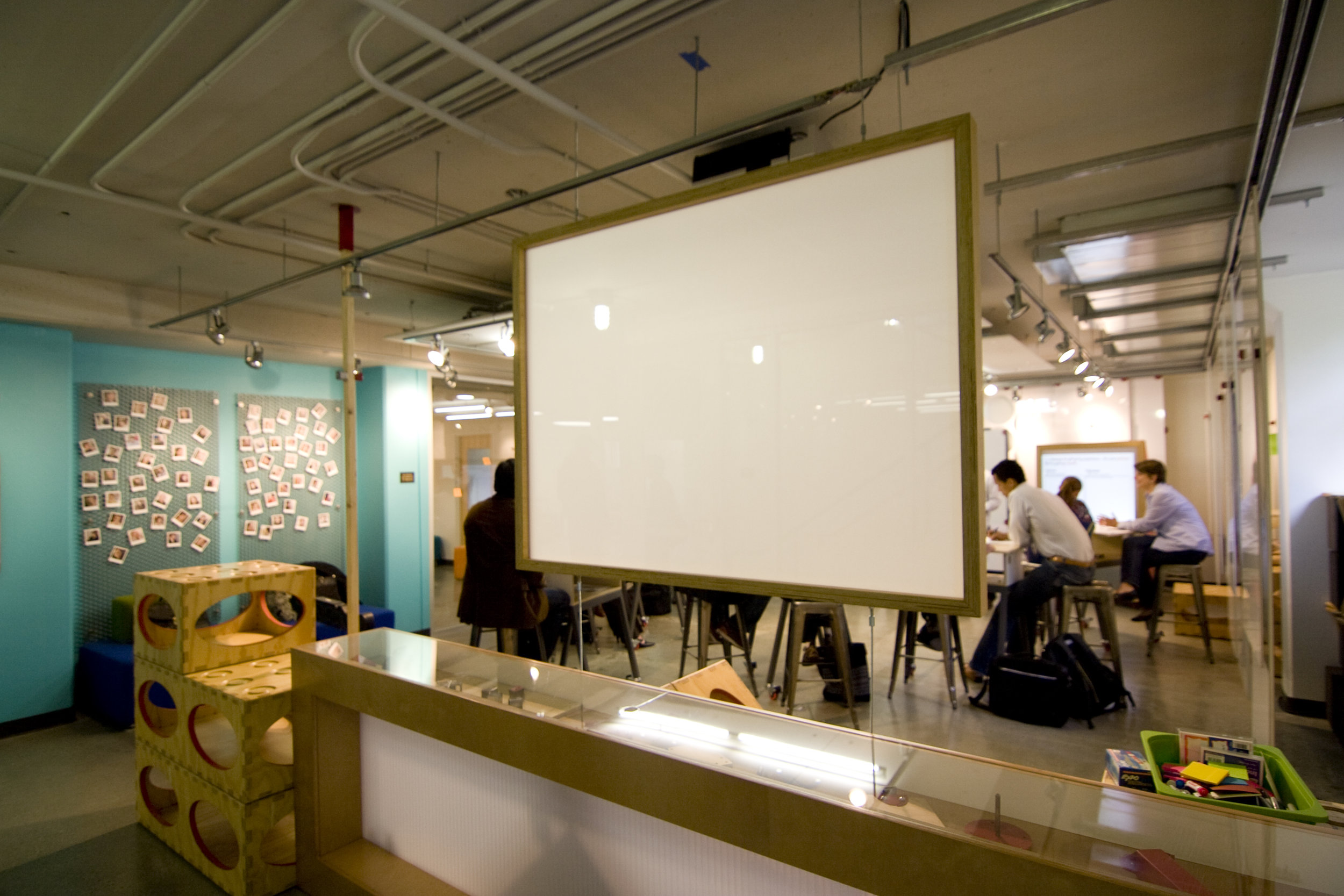 Finally, a clean modern construction for a two sided projector screen floats over the entry way to the space.