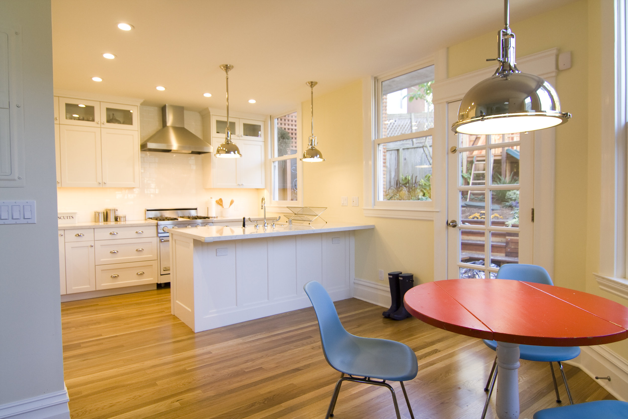  Opening up the interior in a clever way allowed us to almost double the size of the kitchen. Lighting fixtures, white subway tile and other details pull together a warm yet modern feel. 