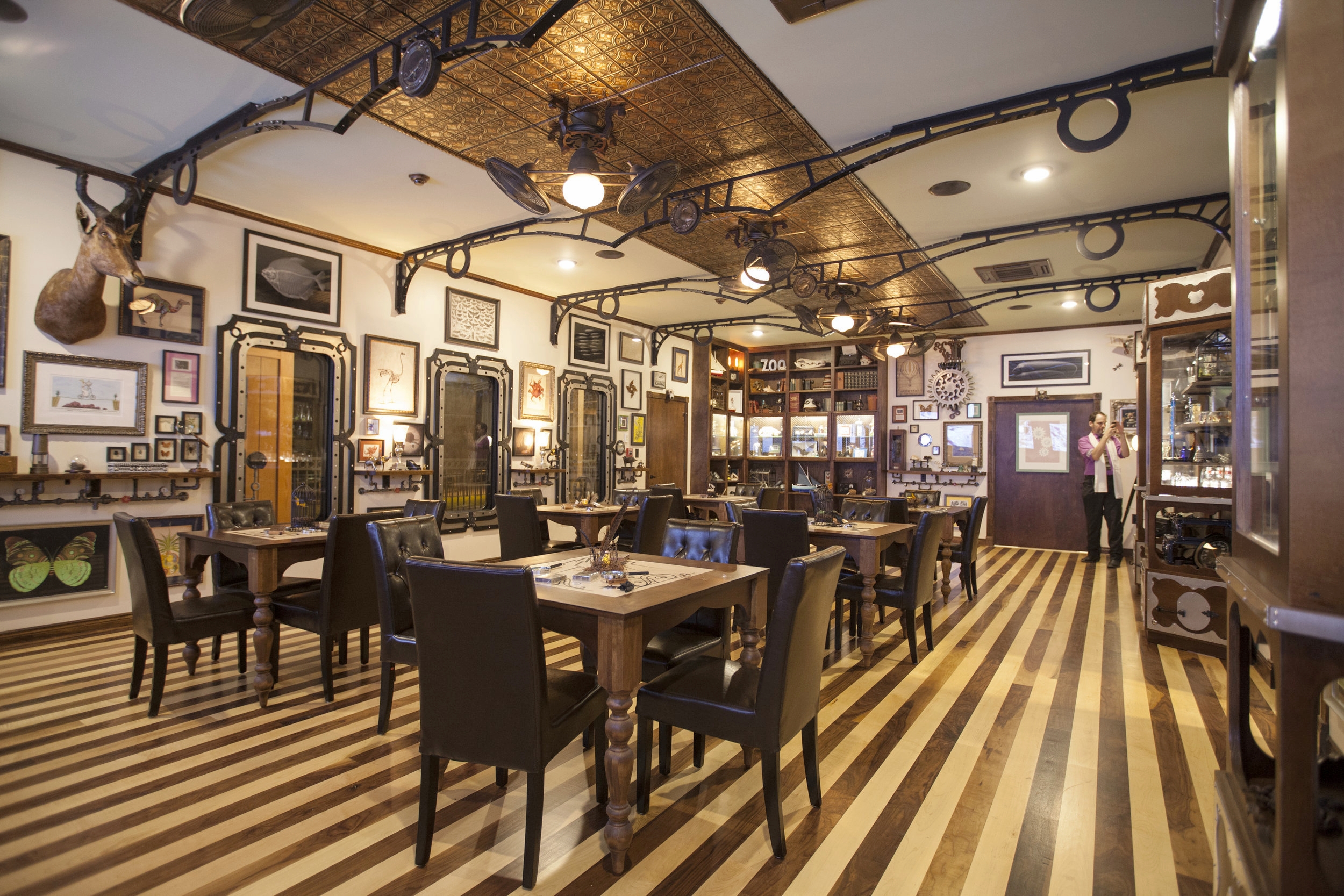  The large room is covered with interest from curio cabinets, art and artifacts to rotating fans above. There are interactive areas for children and adults to explore, and even a secret hidden door.&nbsp; 