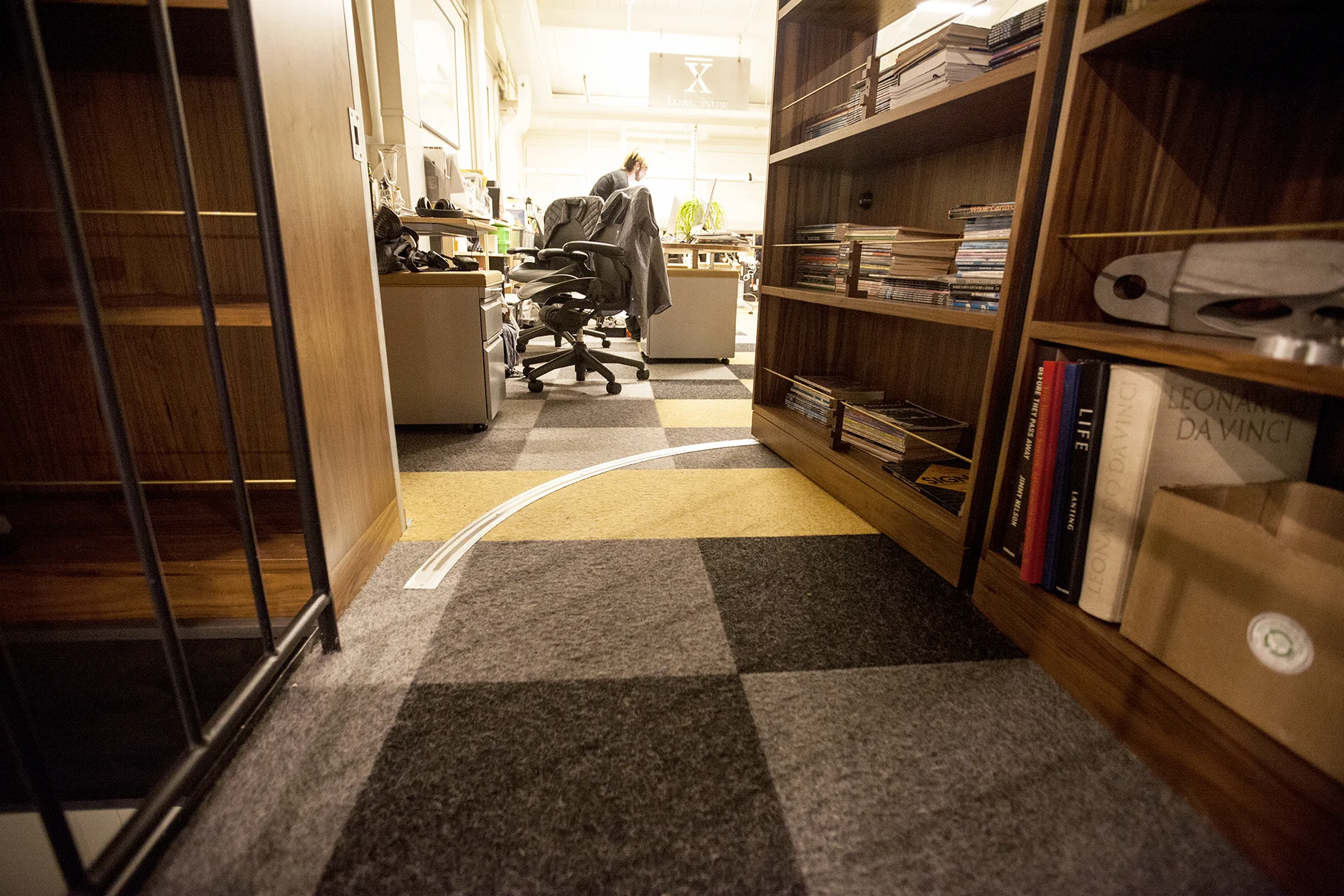 The top of the stairs leads to the floor to ceiling bookshelves, revealing that one of the bookshelves opens (a secret door!) into the office upstairs.