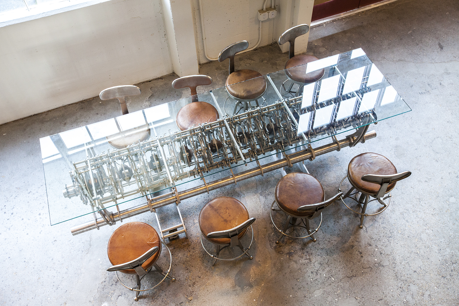 Looking form the top of the stairs, one can see the Chime Generator, an artifact from the Longnow's projects, turned into a glass top table.