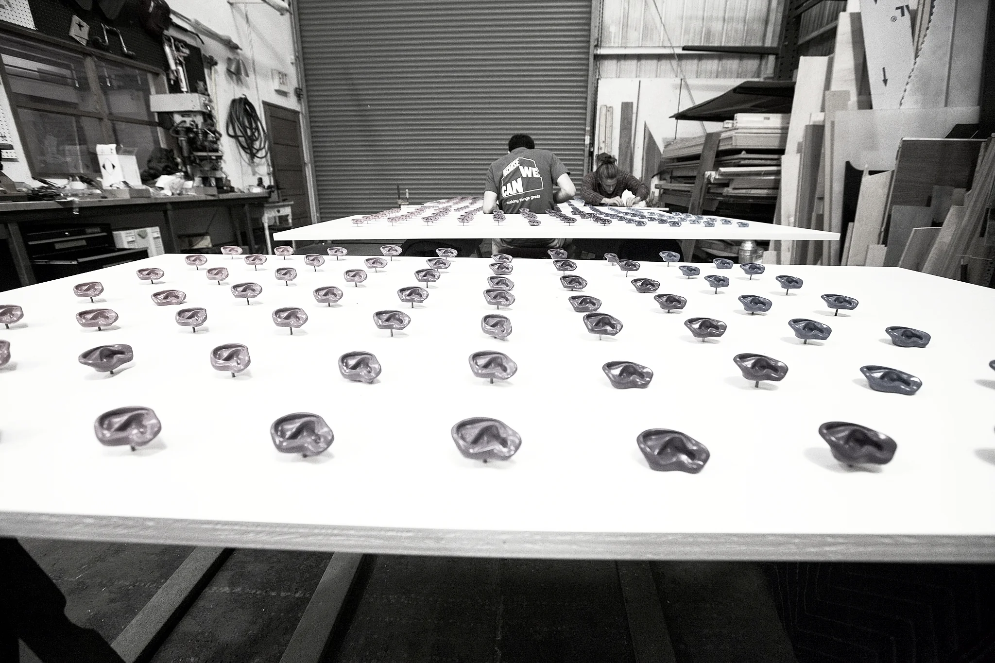 Resin cast ears in a gradient of colors lined up and ready for their final assembly.