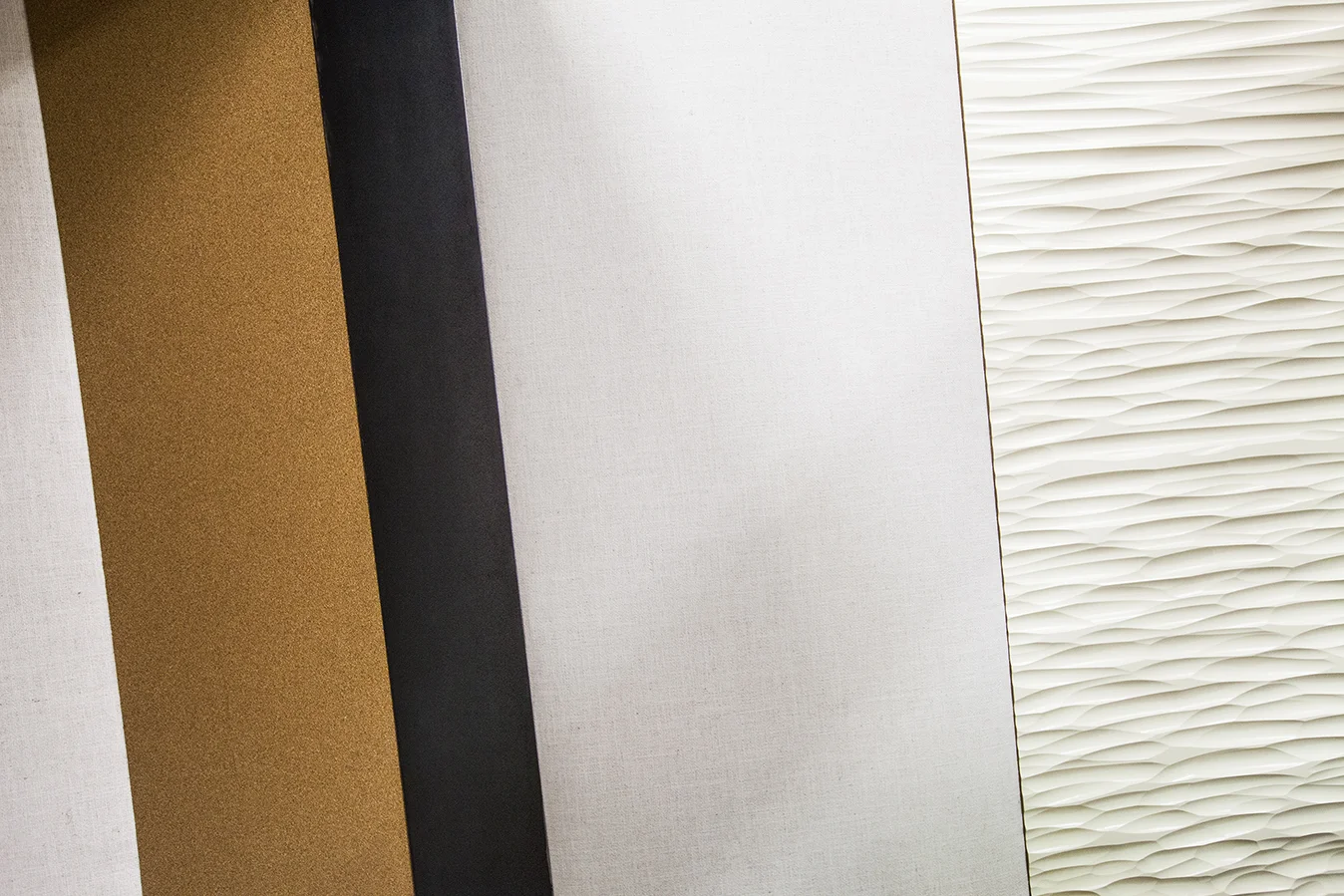 The different materials meant to be both useful and interesting. The dark brown is cork (pin up board), the black is steel (magnet board) the soft white is a fabric (pin up board). The hewn panel is for decorative interest, and like the other materials, helps with sound.