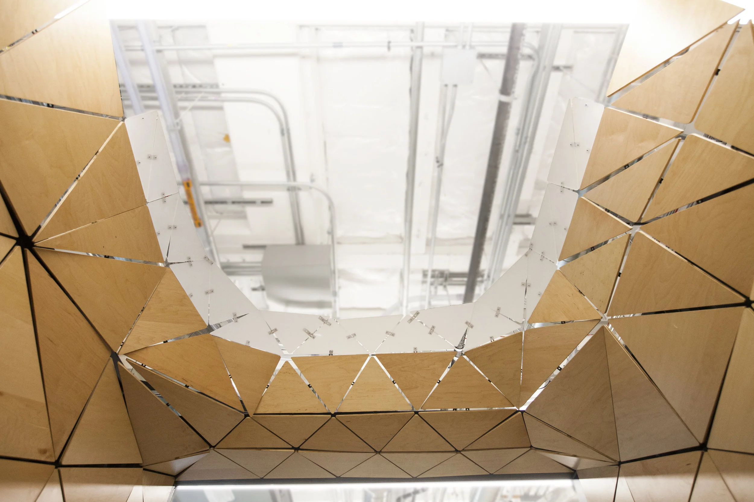 Looking up into the opening of the triangle container, the enclosing half circle continues the soft feel of the interior.