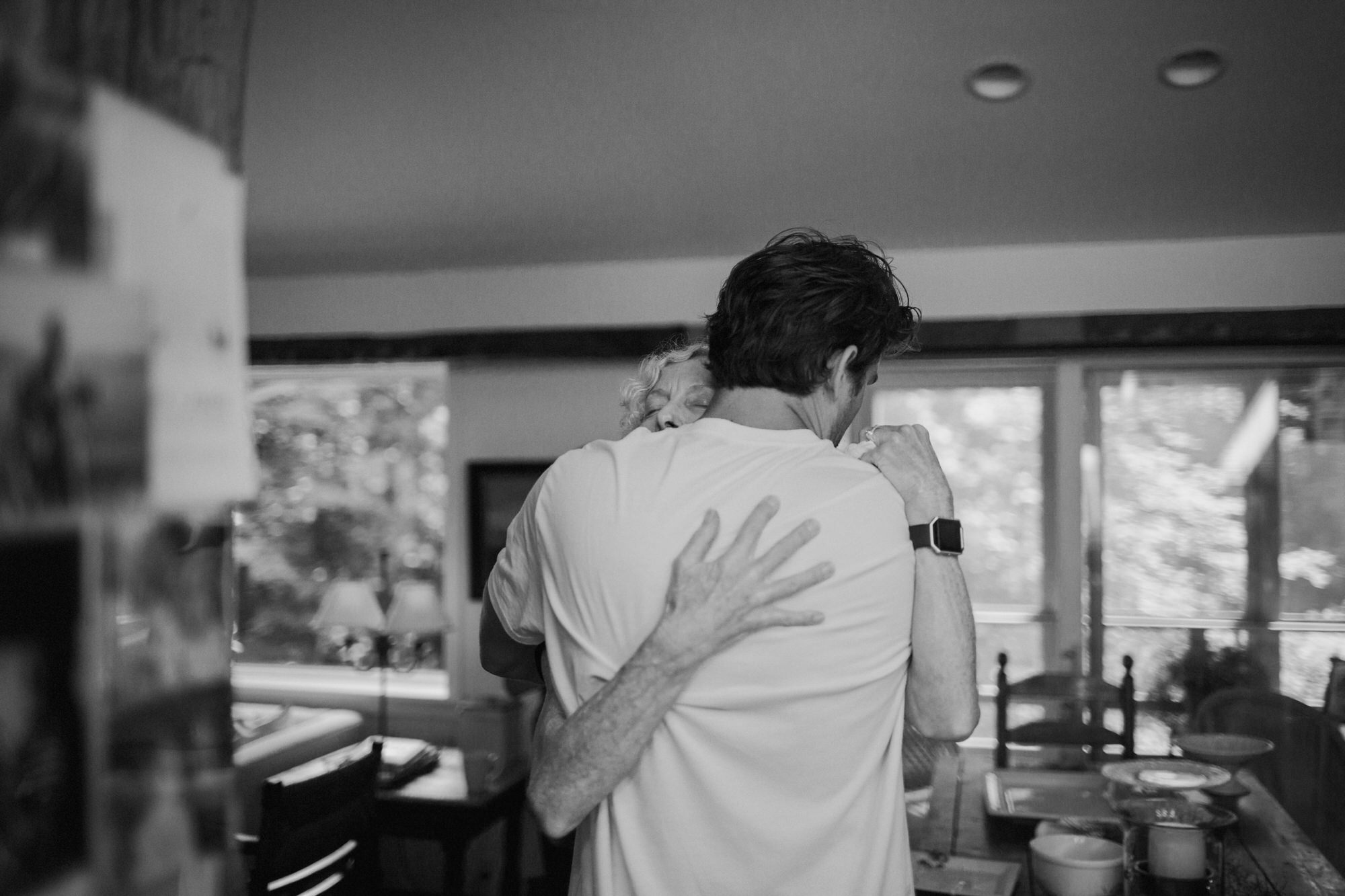 mother of the bride hugging her son