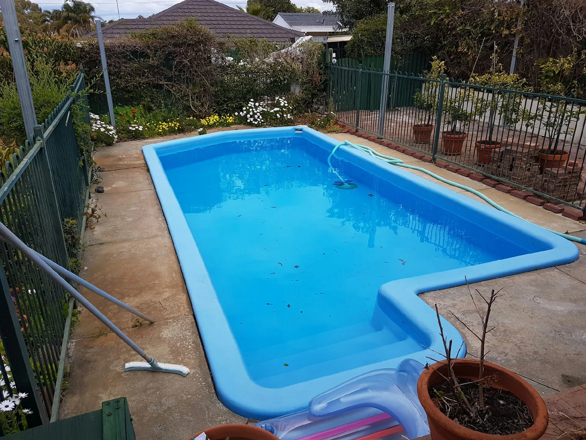 Before: This outdated pool area needed some work, with new paving and fencing. 