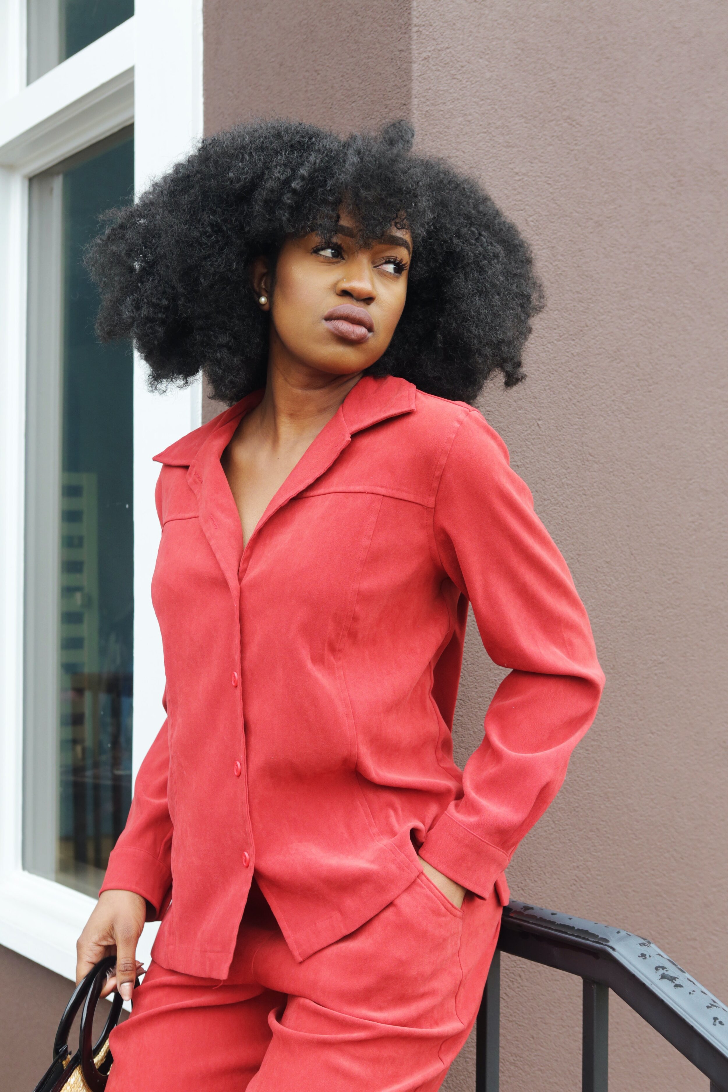 woman-in-red-dress-shirt-and-pants-leans-on-stair-railing-2005356.jpg