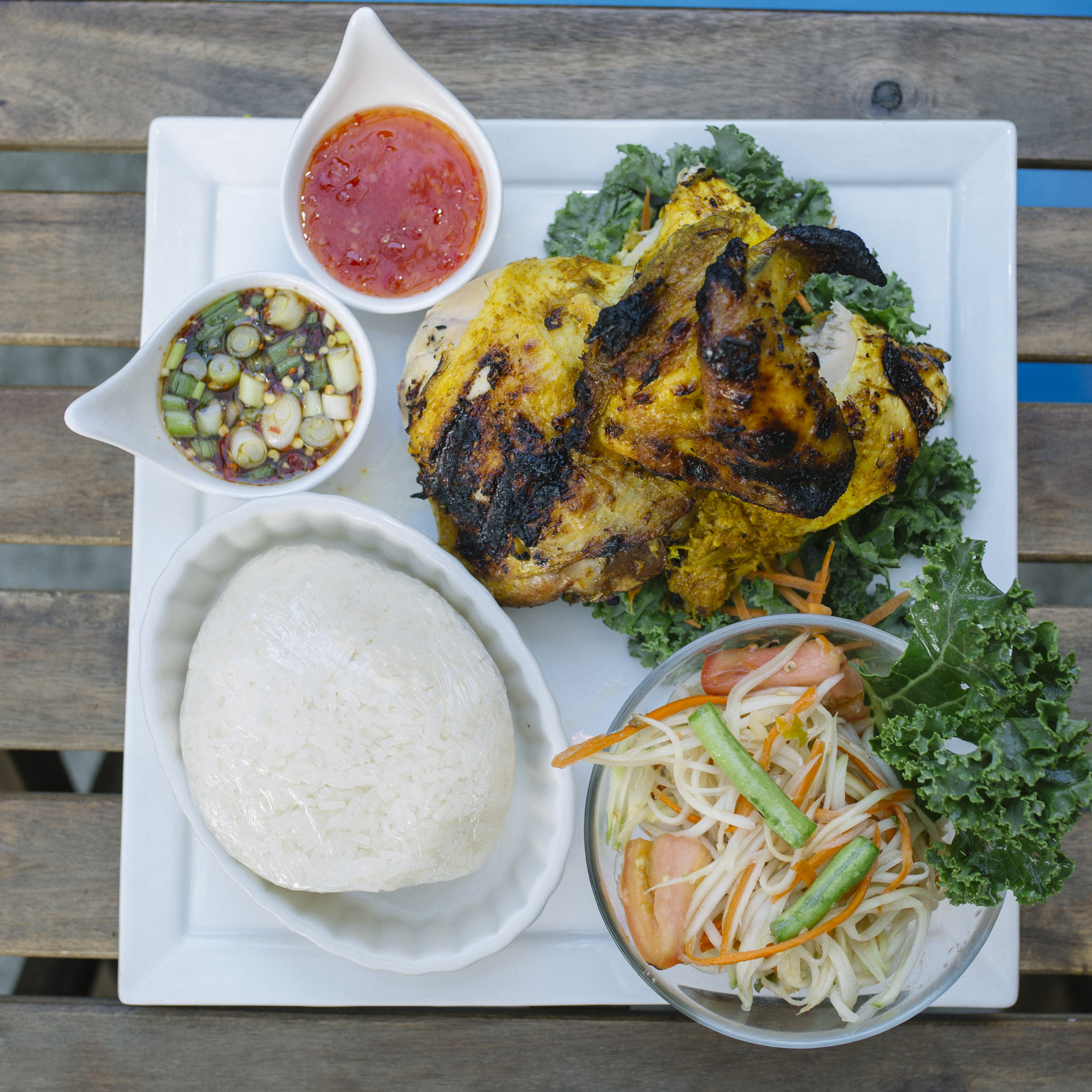 Gai Yang Khao San Kwang - Half Chicken Marinated with Herbs and Roasted to Perfection served with Tum Thai and Sticky Rice