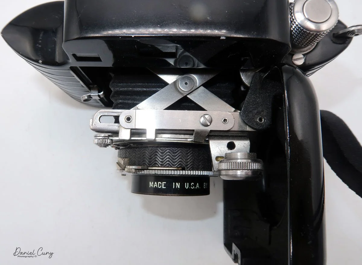 Scissor style truss for the lens