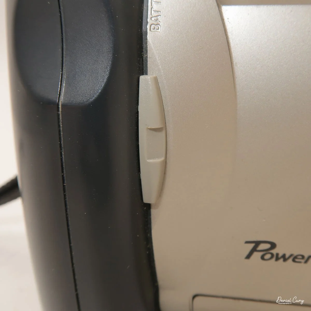 Slider on grip to open battery compartment