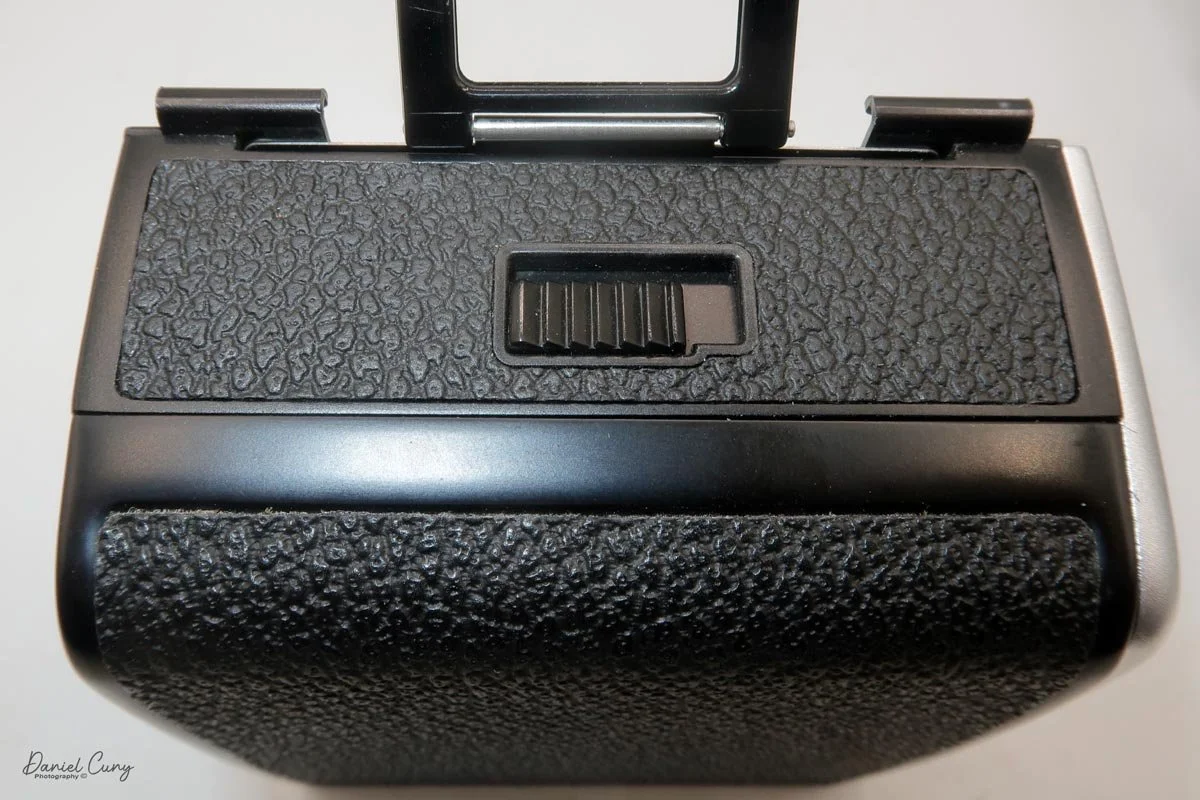 Slide lever up and over to open the film back