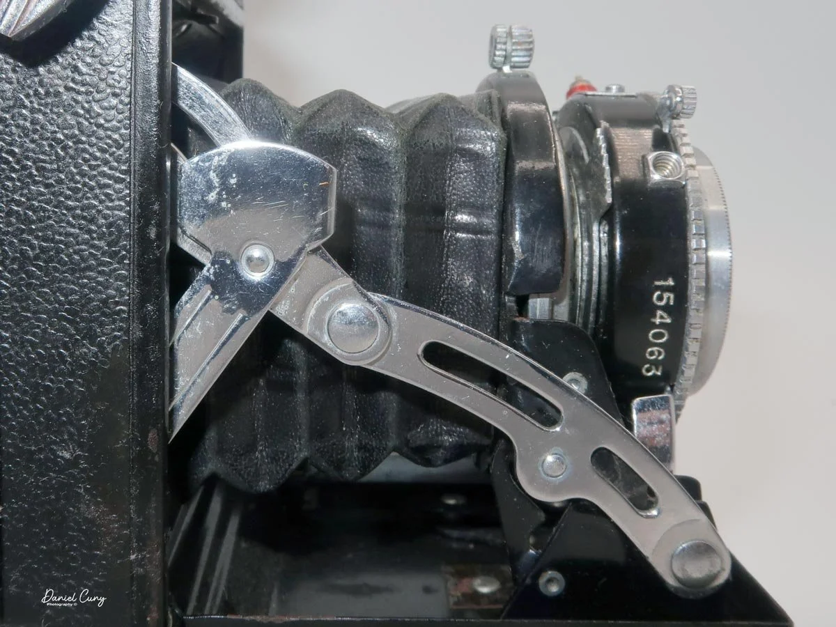Press in on struts to close lens door.