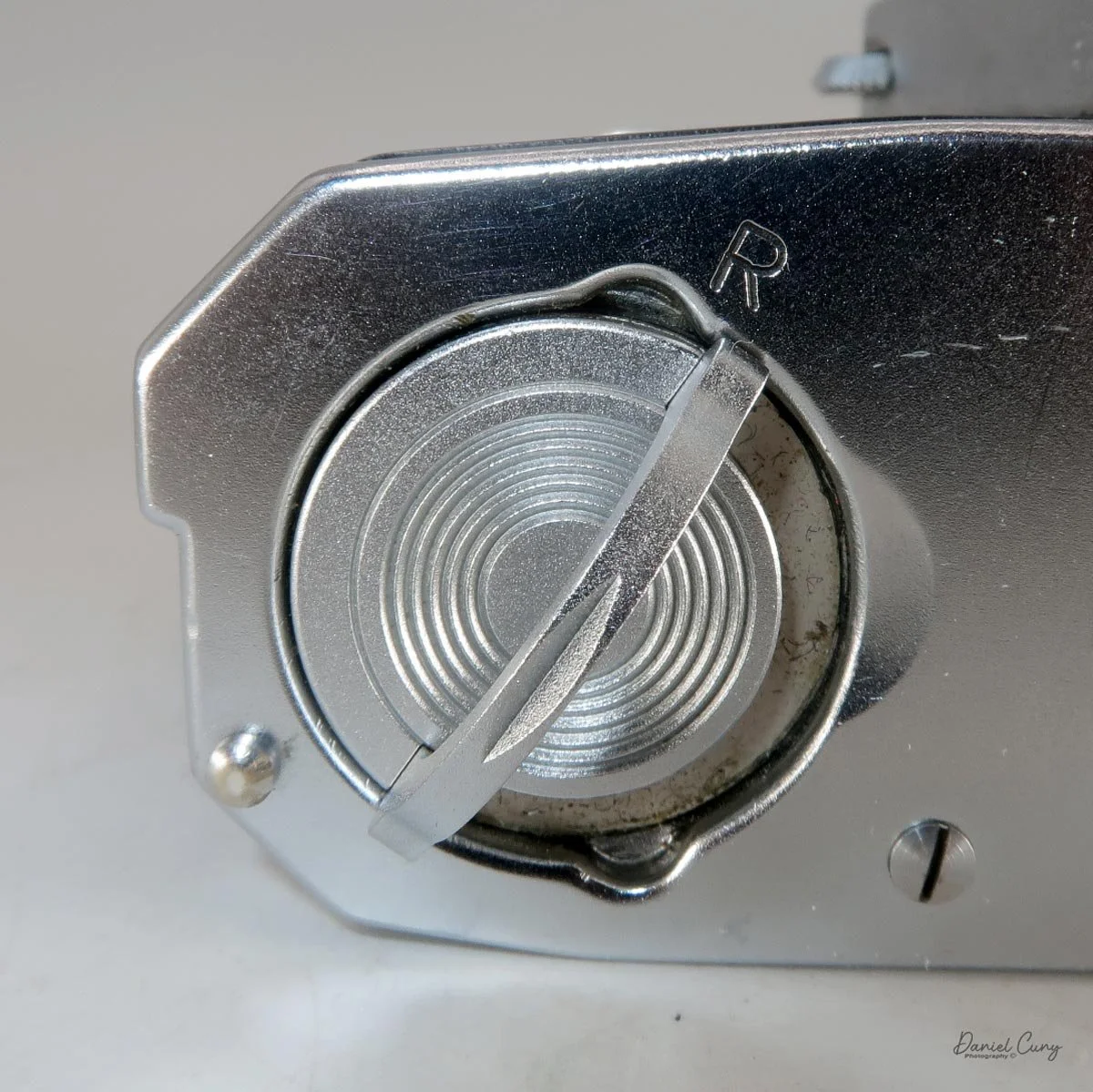 Turn latch to "R" to rewind the film