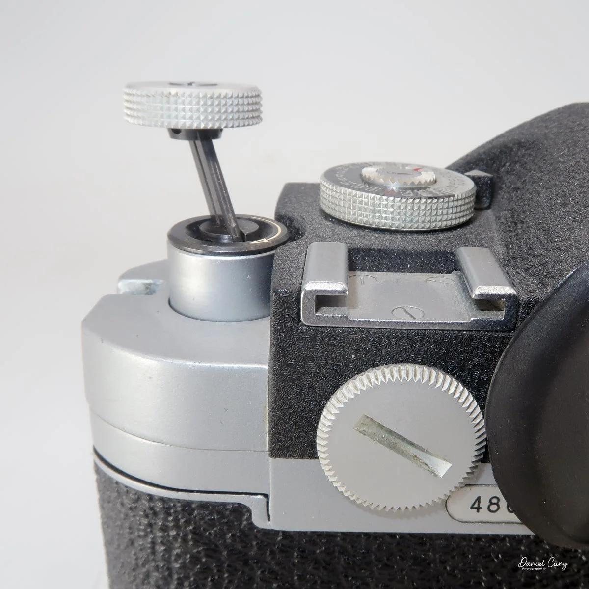 Pull up rewind knob to rewind film into canister